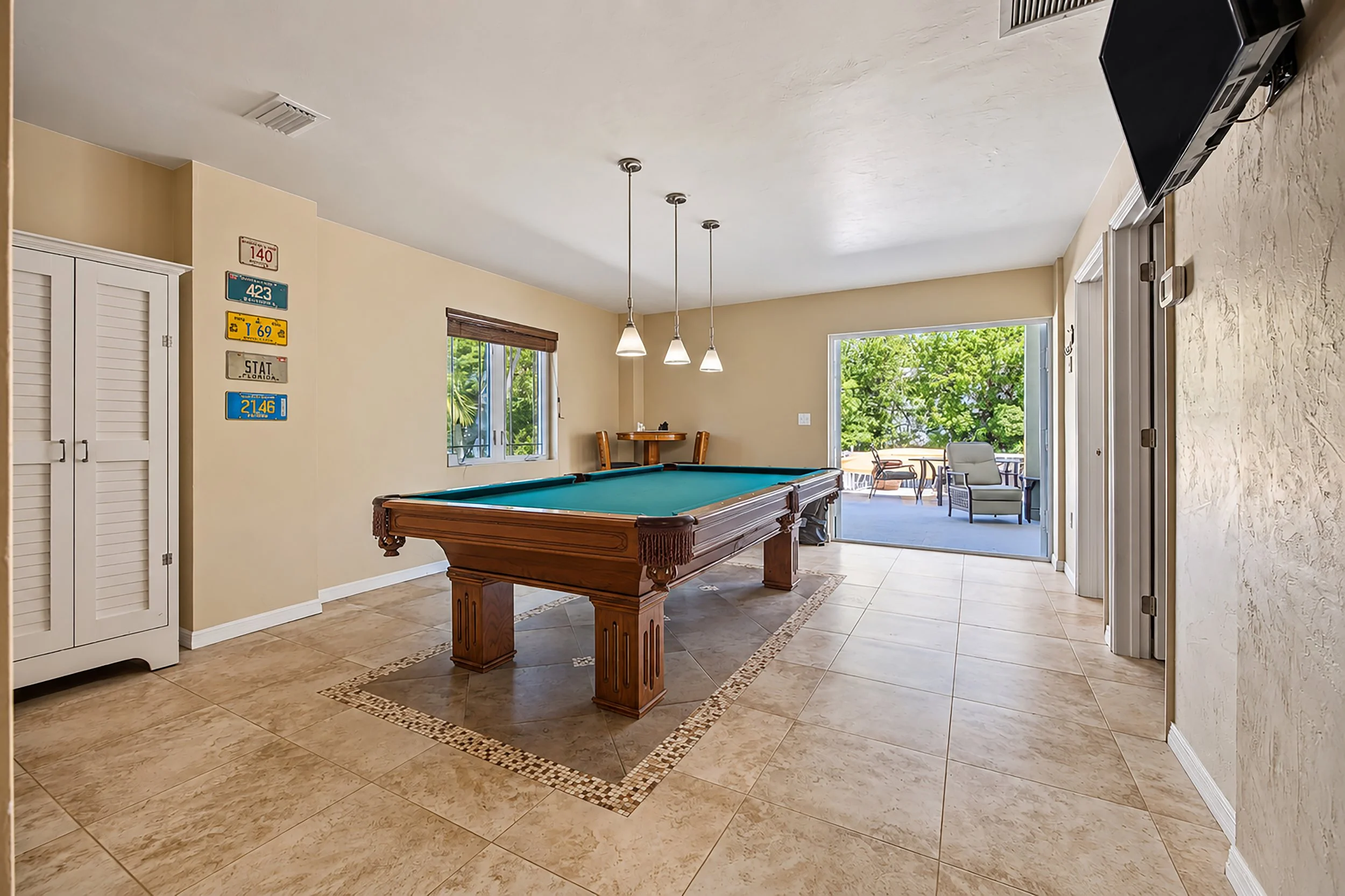 Billiard and game room with pool table and access to an outdoor patio in a Key Largo, Florida home