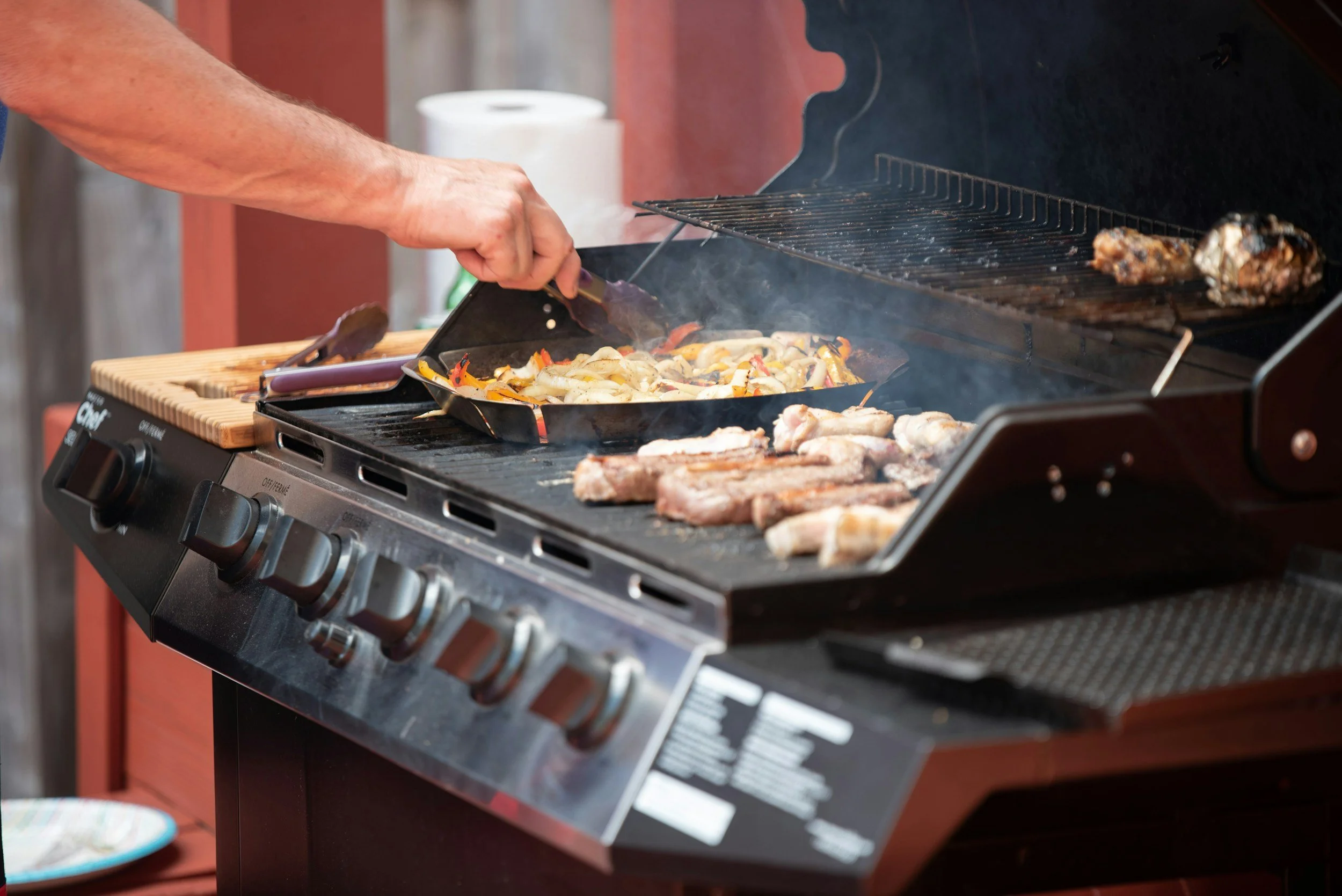 Gas barbecue with meat and onions grilling
