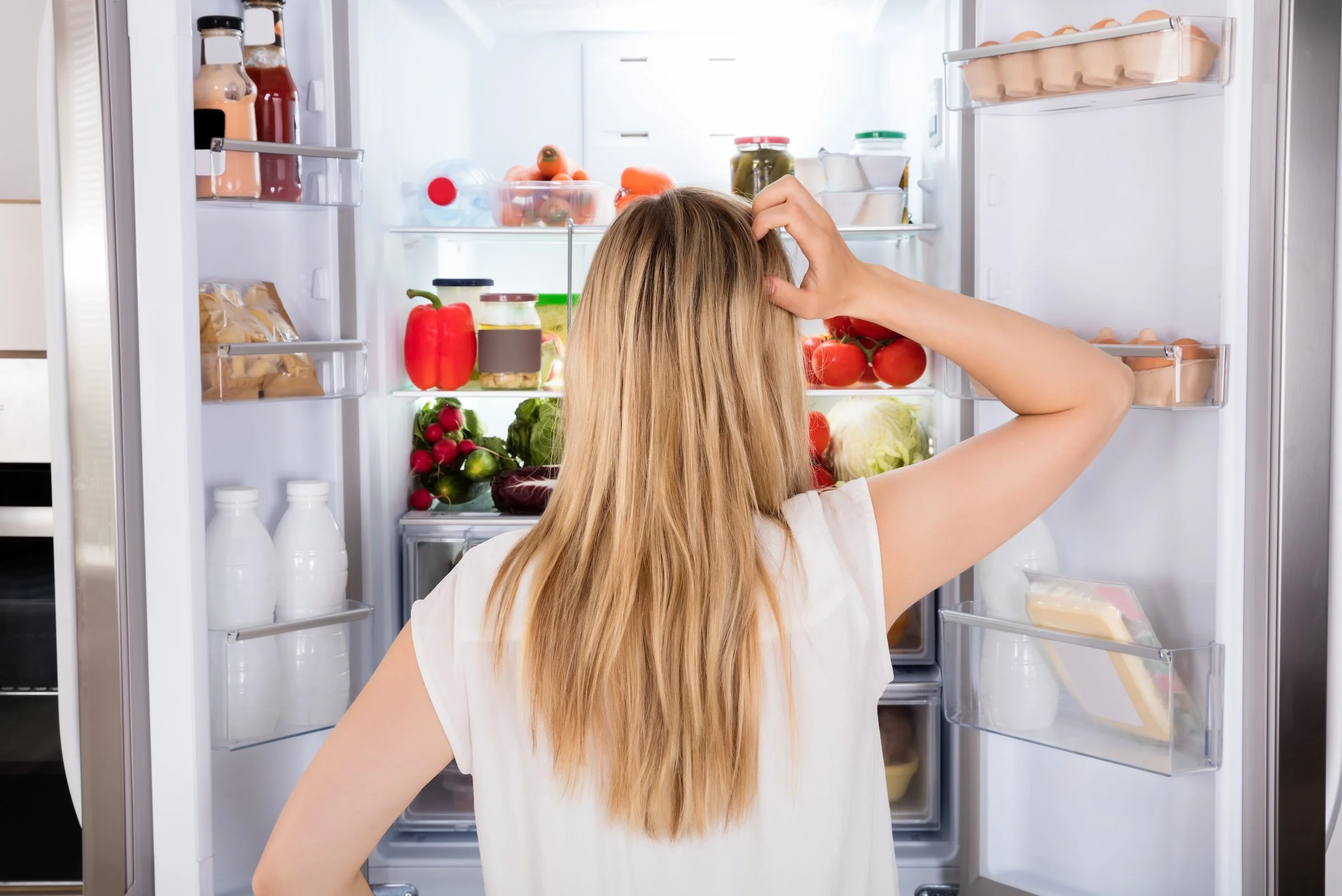 woman looking in refrigerator
