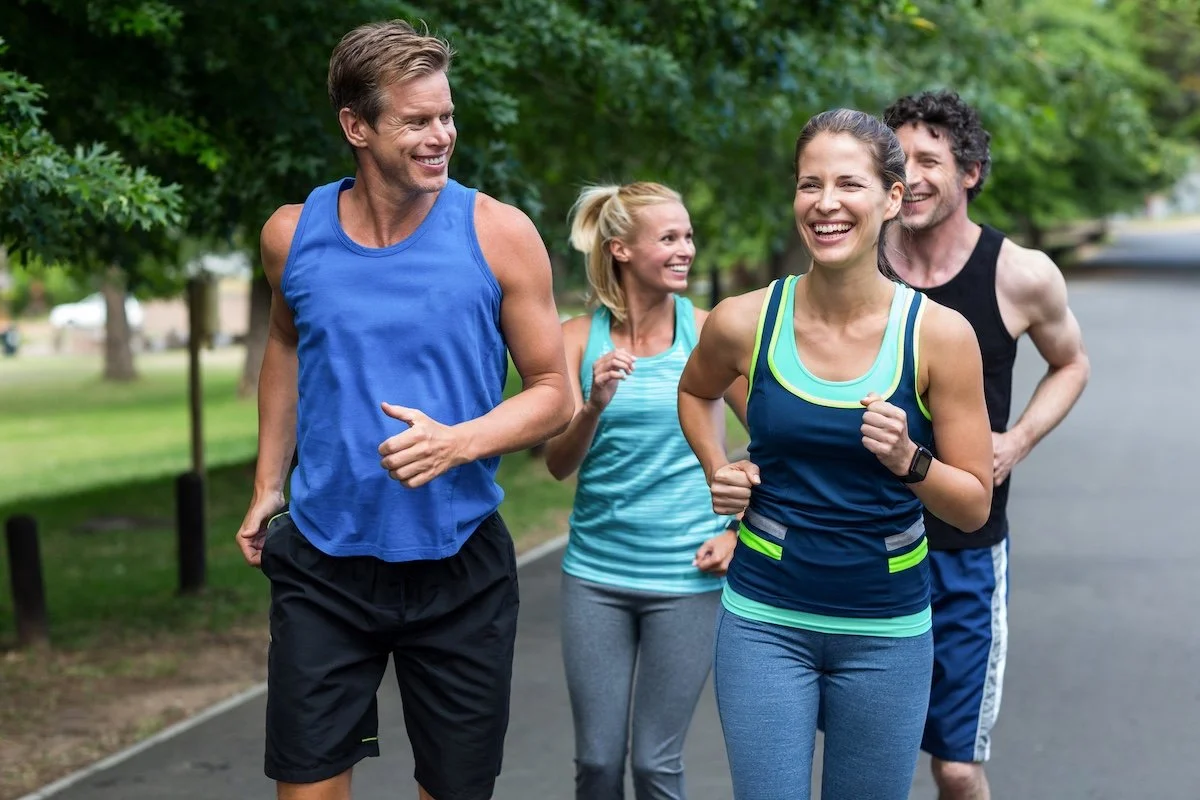 Younger adults running in a park