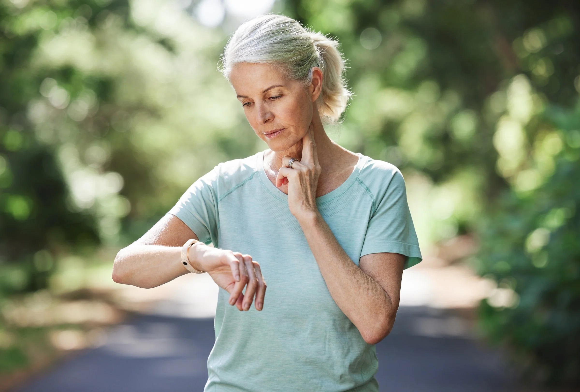 woman checking pulse outside after exercising