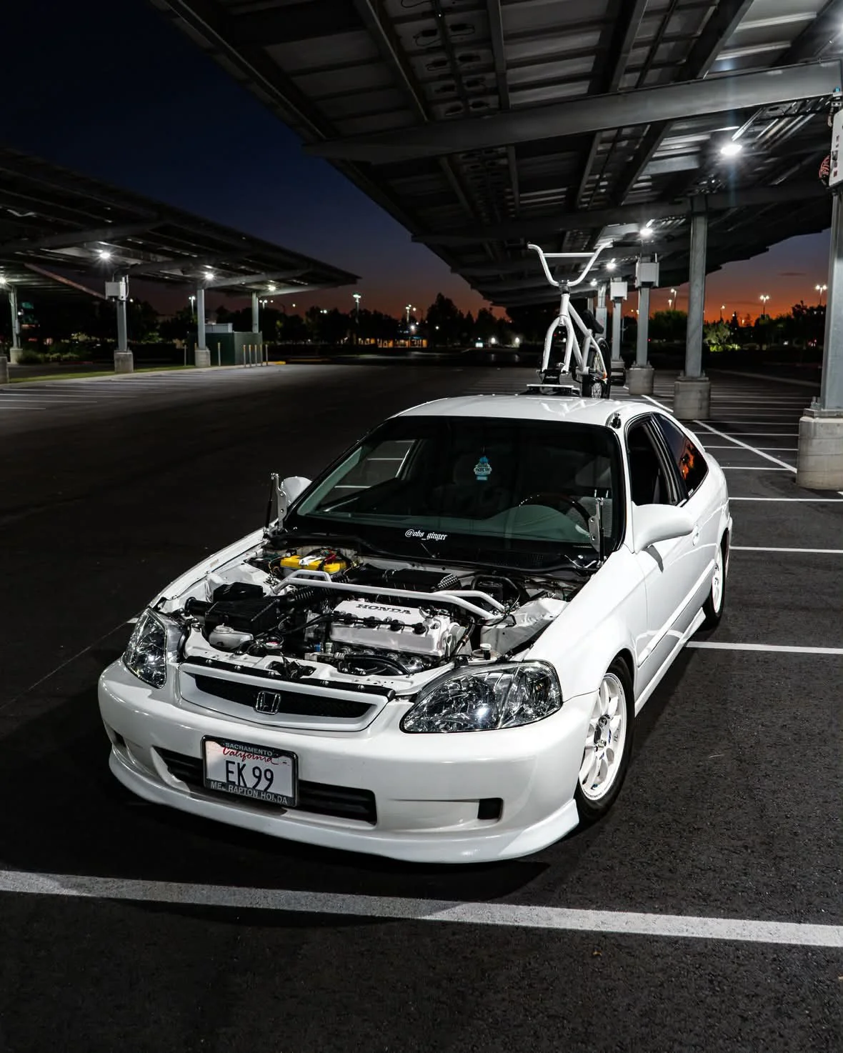 Christian's white Honda Civic with a bike mounted on the roof