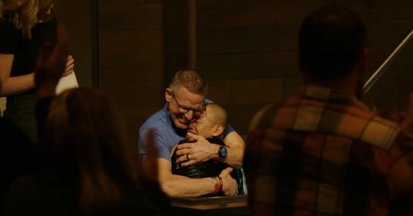 Two men embracing after celebrating a changed life through baptism.