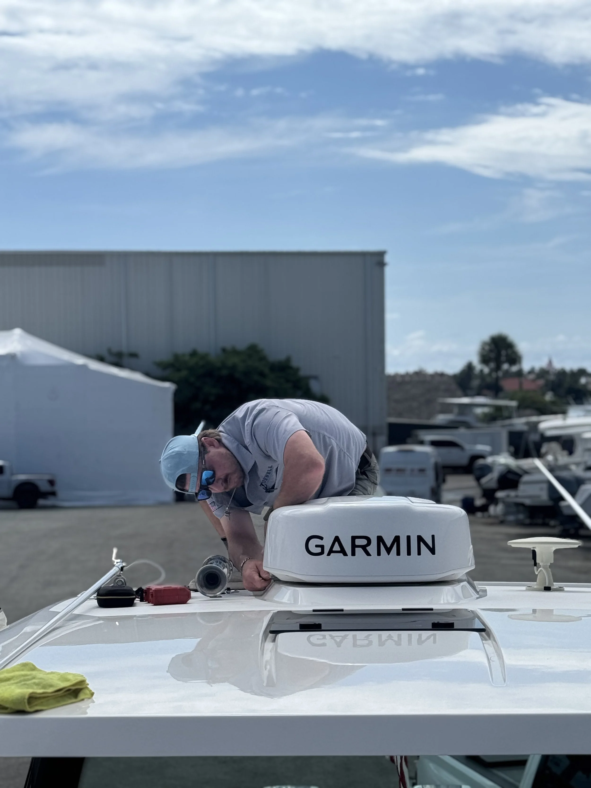 Marine technician servicing a Garmin device on a boat