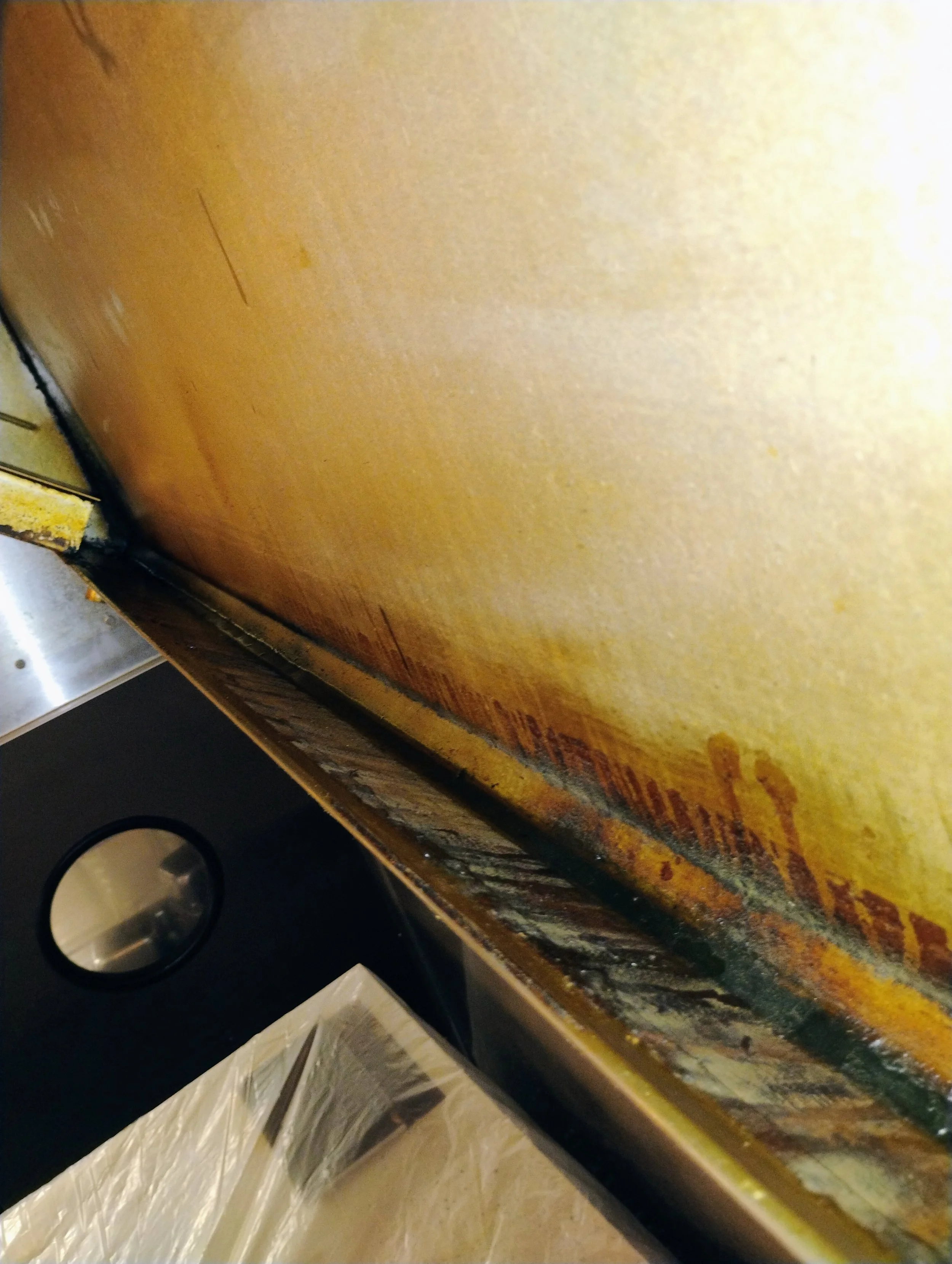 Close-up of a greasy, stained kitchen oven or stove surface with visible grime and burnt residue.