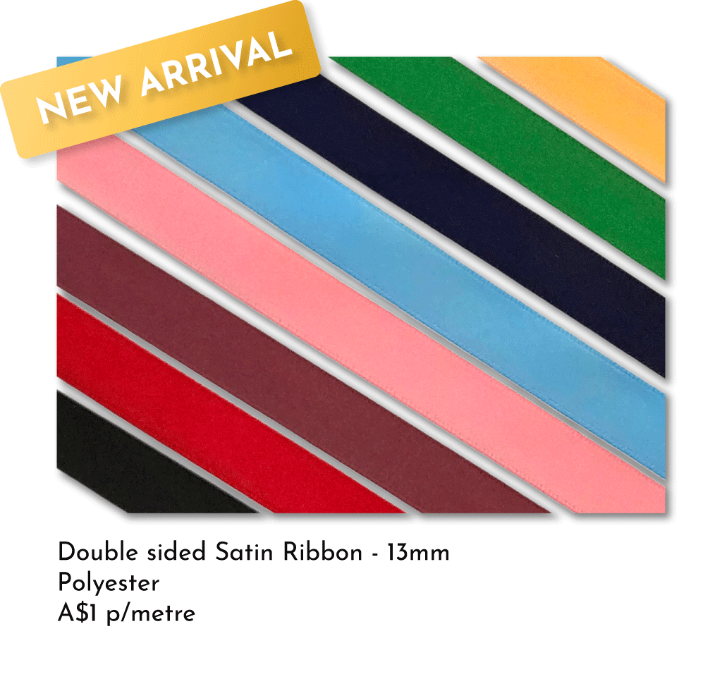 A display of multiple double-sided satin ribbons in various colors, including pink, red, black, blue, and green, with a yellow banner at the top left corner that reads "New Arrival."