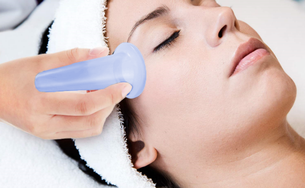 A woman receiving a facial treatment with a handheld device on her cheek.