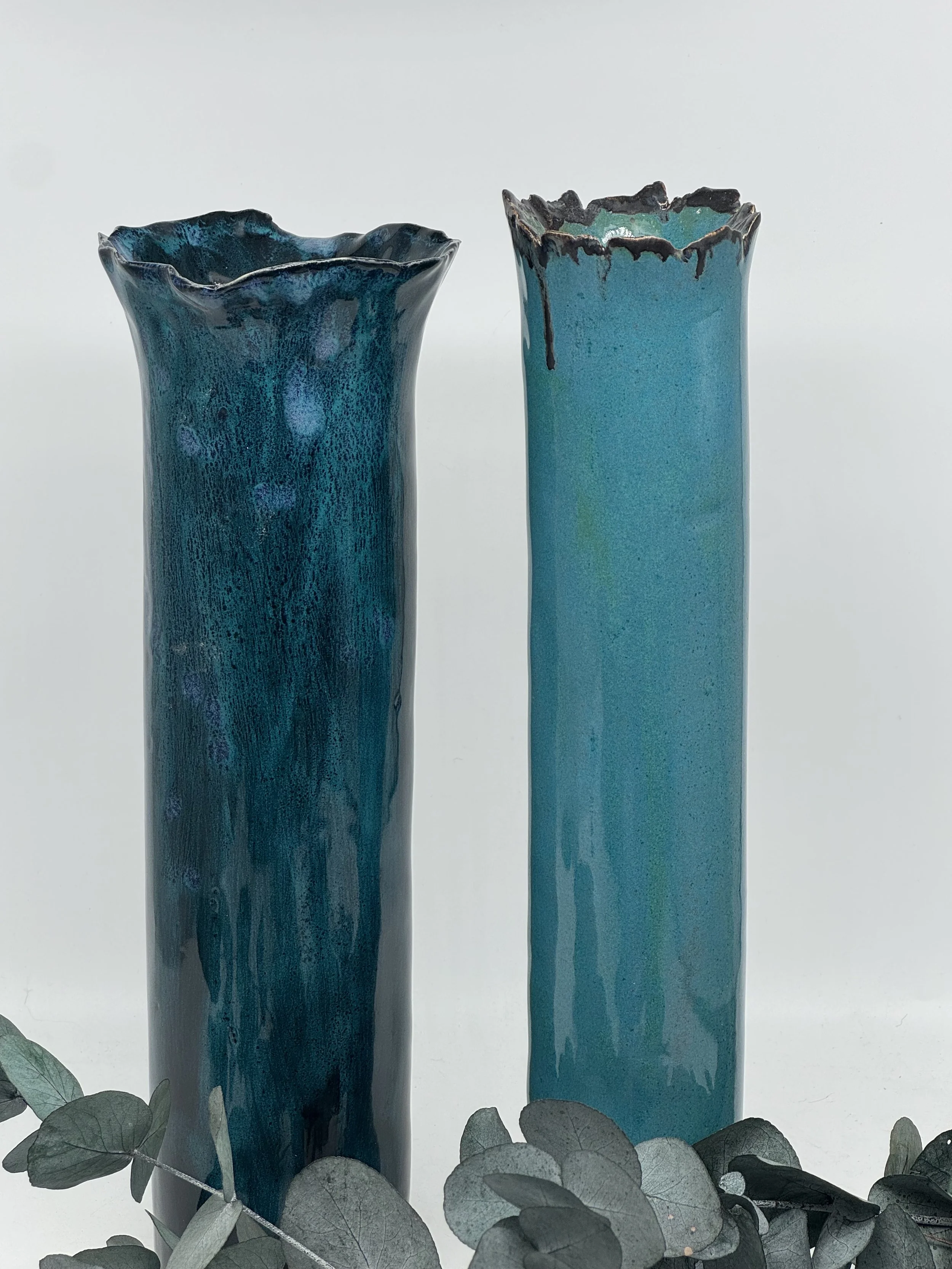 Tall teal vases.   Solid bases and both with unique glazing finishes.   