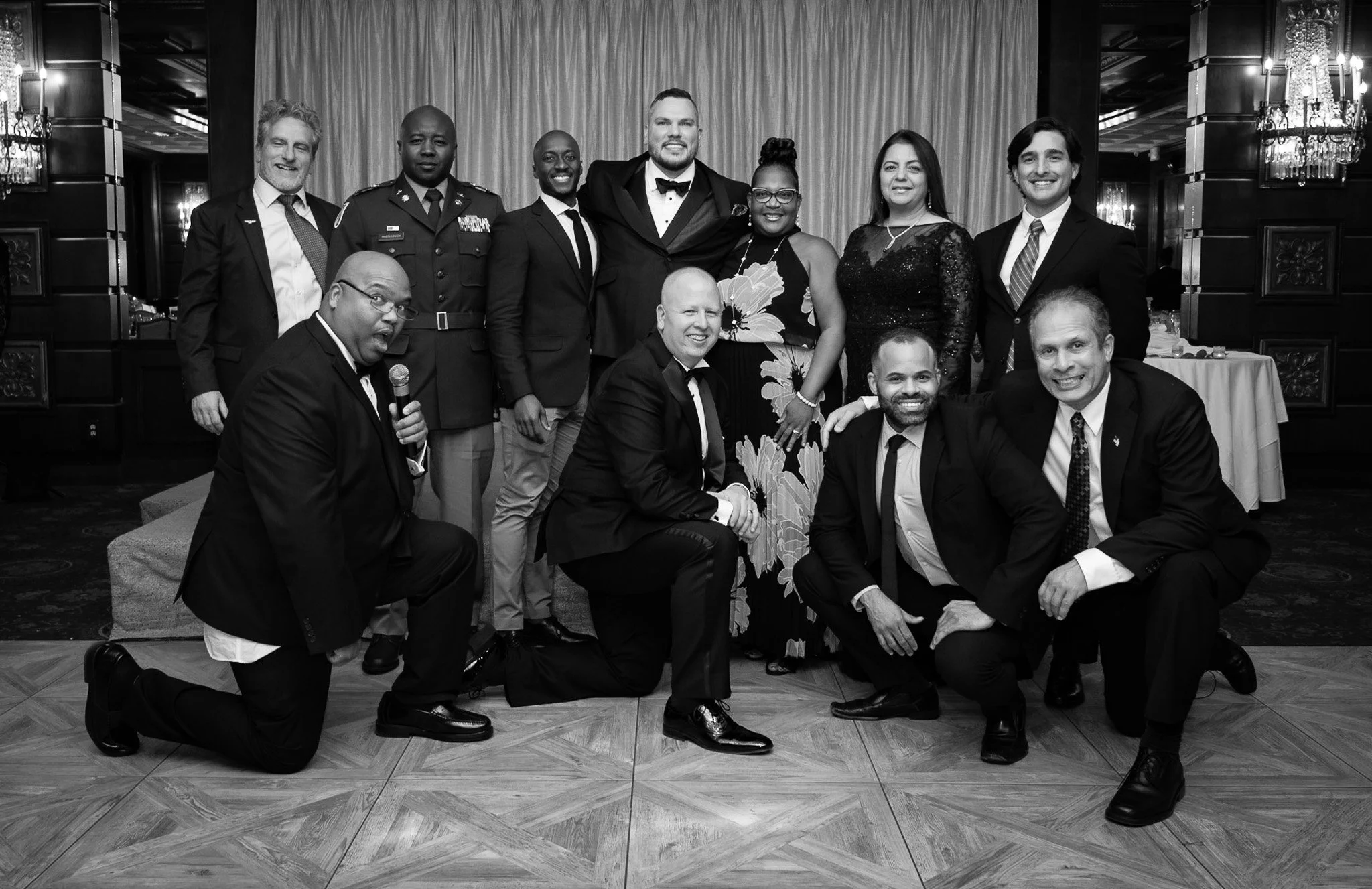 Group of people in formal attire at an indoor event, posing for a photo.