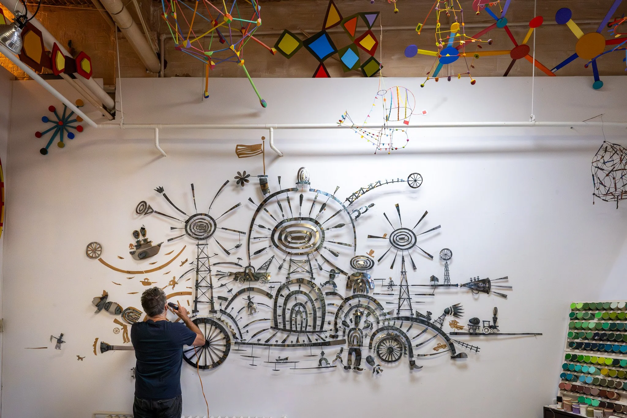 Multimedia male artist creating large metal artwork