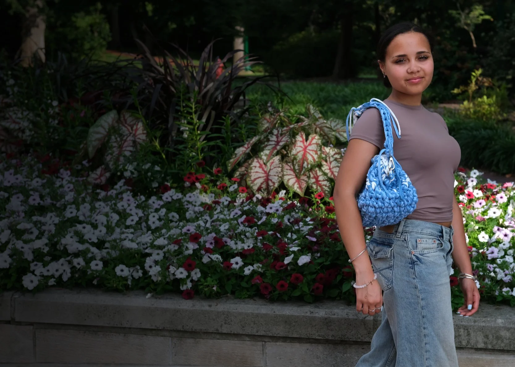 Model wearing a Yarn Know clutch bag in a garden