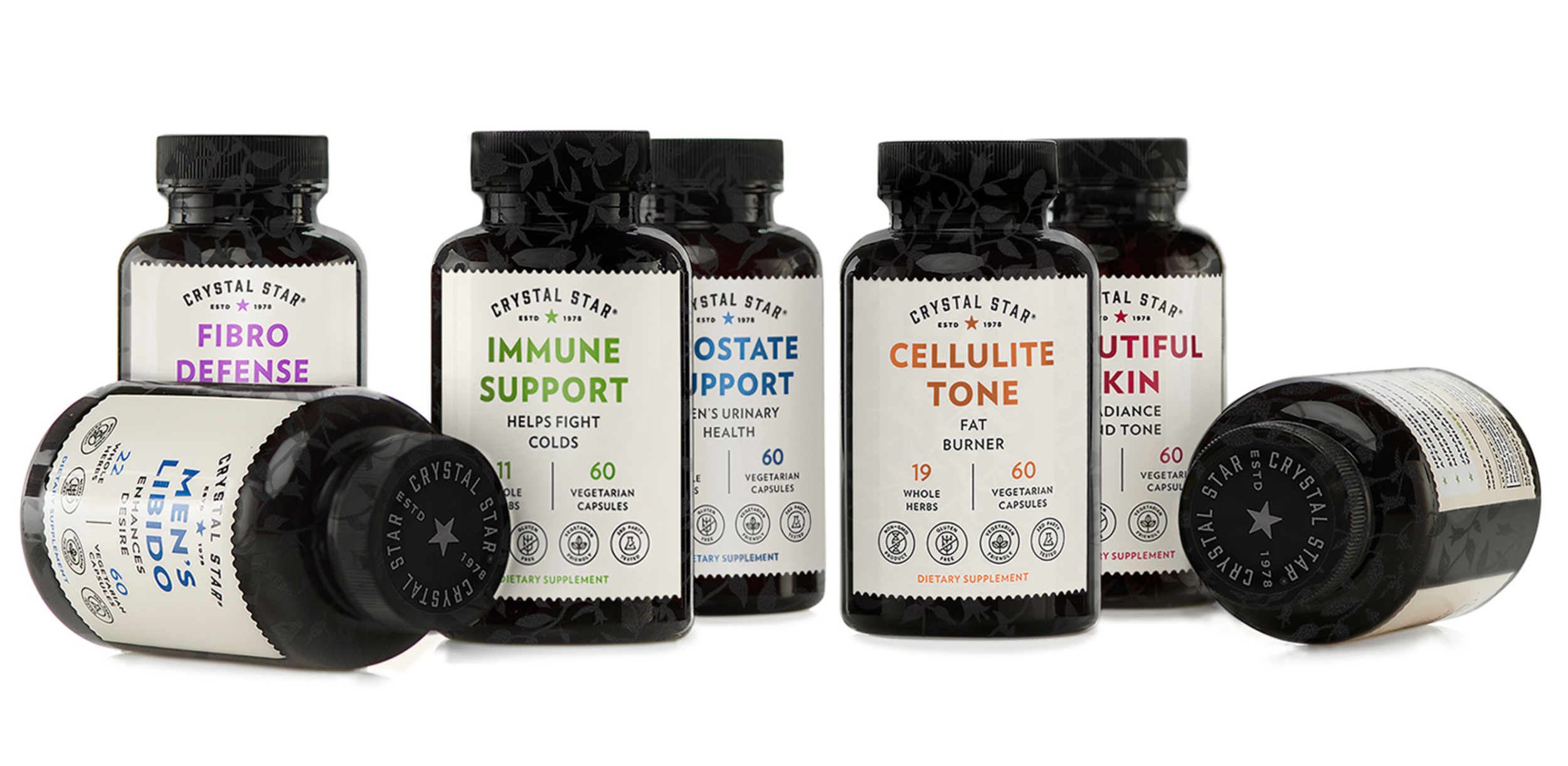 A lineup of dietary supplement bottles from Crystal Star, with labels for Fibro Defense, Immune Support, Oste Support, Cellulite Tone, and Nutiful Skin, arranged on a white background.