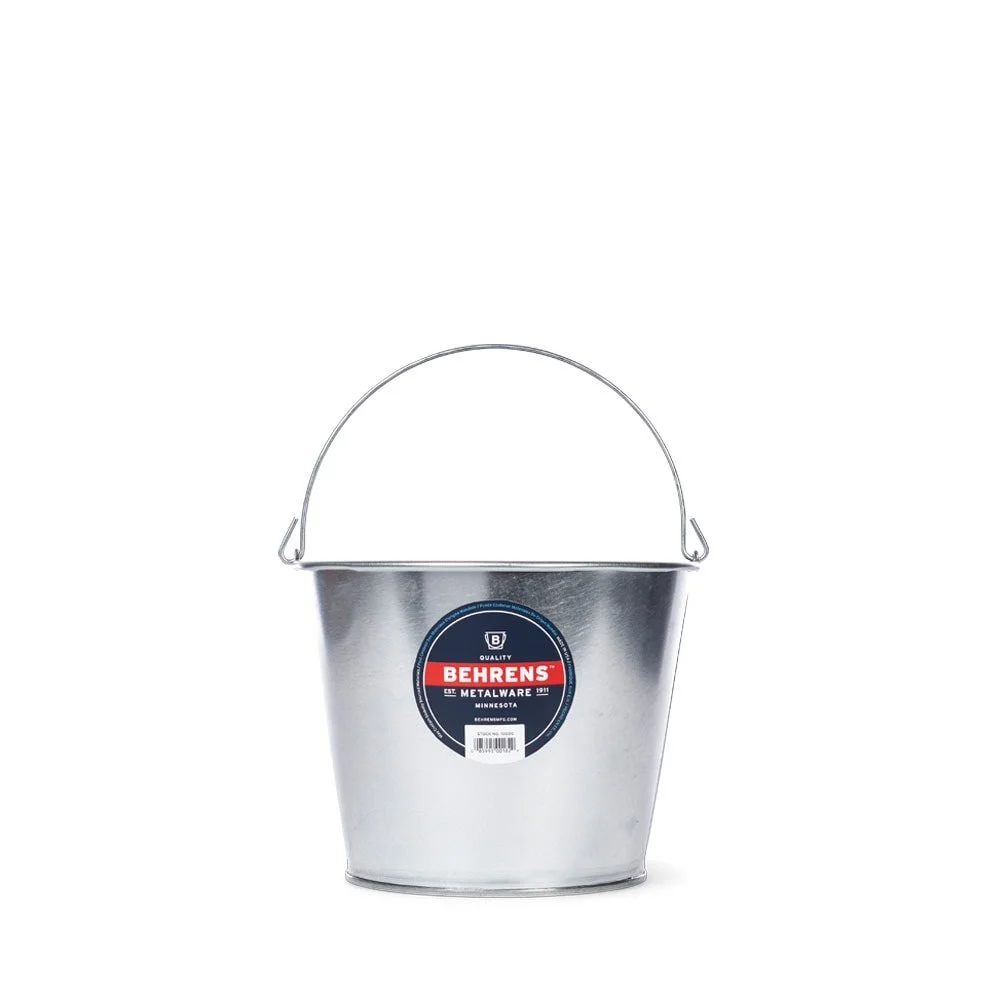 A silver metal bucket with a handle and a black and red Behrens label on the front.