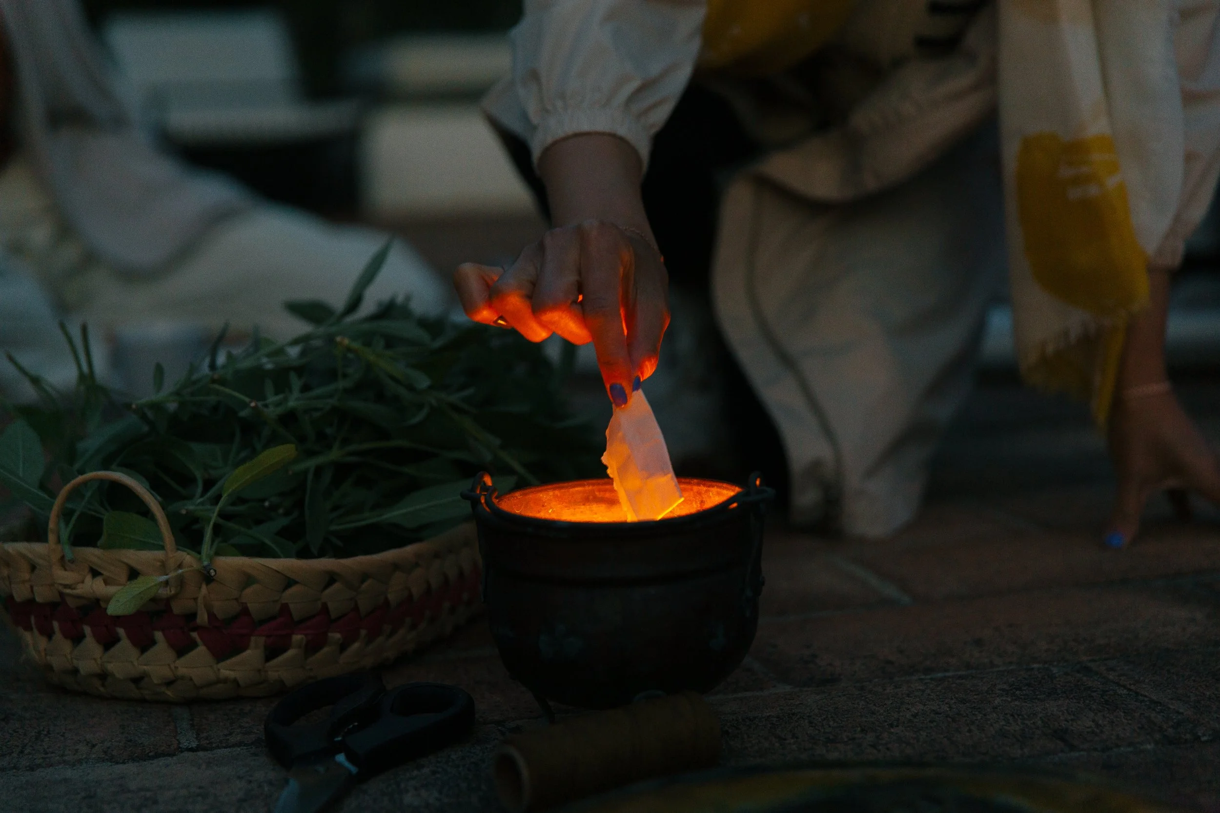 a hand placing paper into the fire