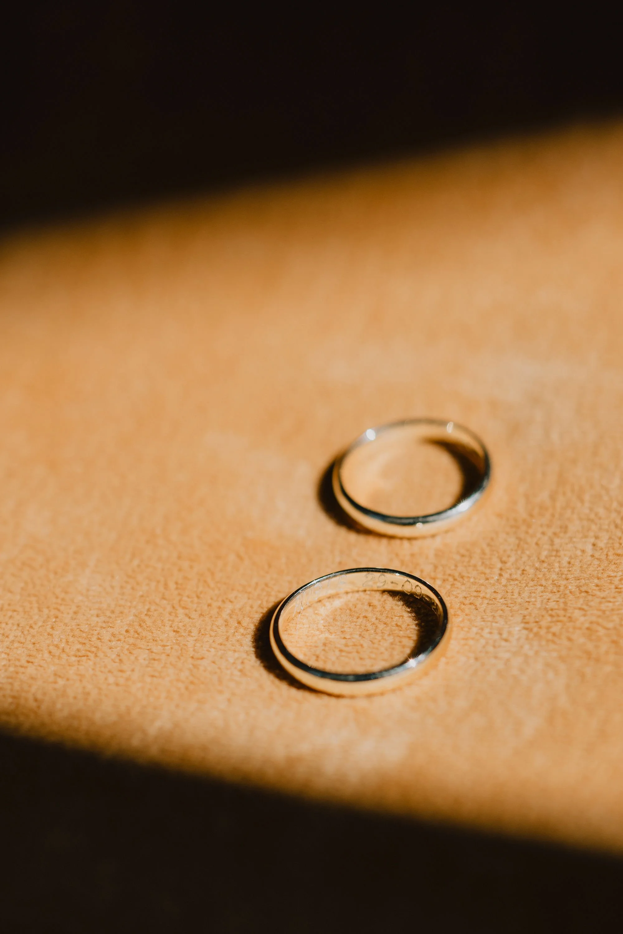 Anillos de bodas de plata y oro sobre bandeja de cuero. Elegante. Bodas y eventos. Madrid