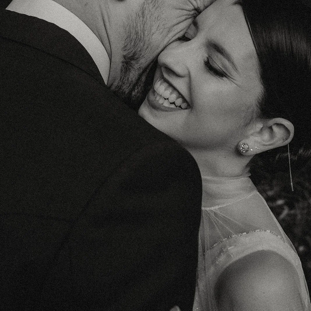 Una pareja abrazada, sonriendo y mostrando afecto en un momento íntimo. Bodas y eventos. Madrid.