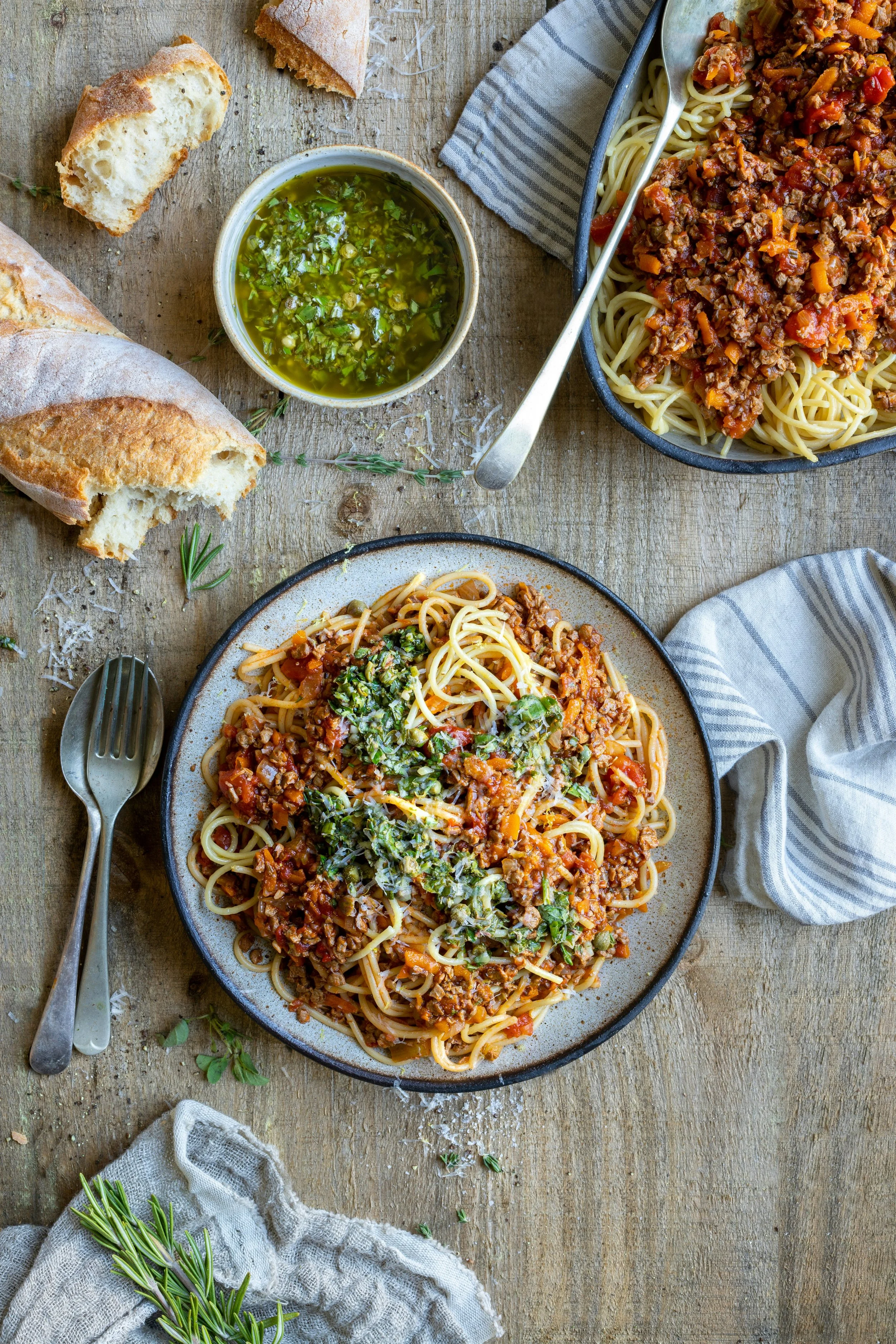 plates with pasta bolognese and cutlery on the side