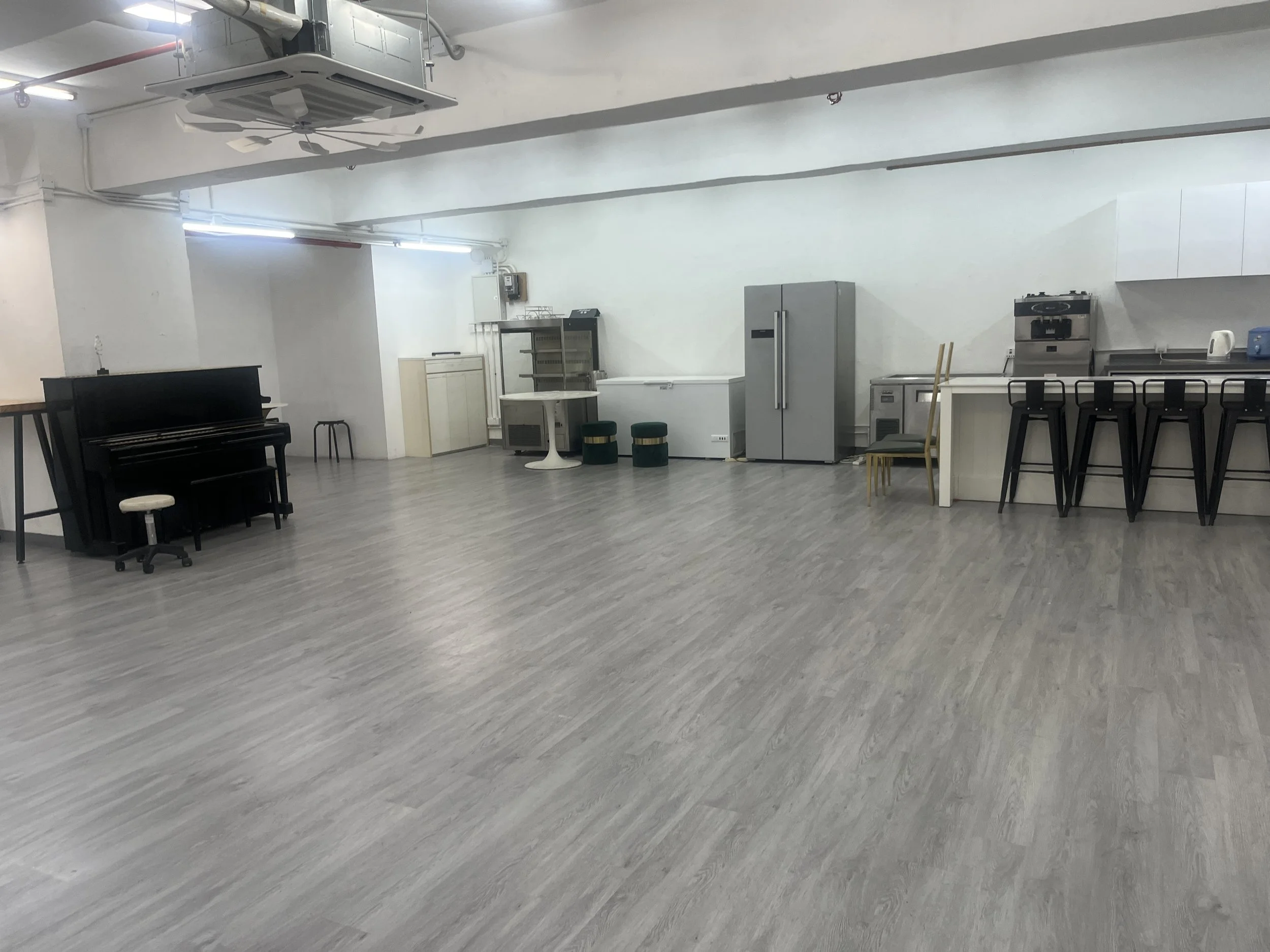 An open kitchen counter studio equipped with bar stools and double refrigerators for private catered functions in Wong Chuk Hang.