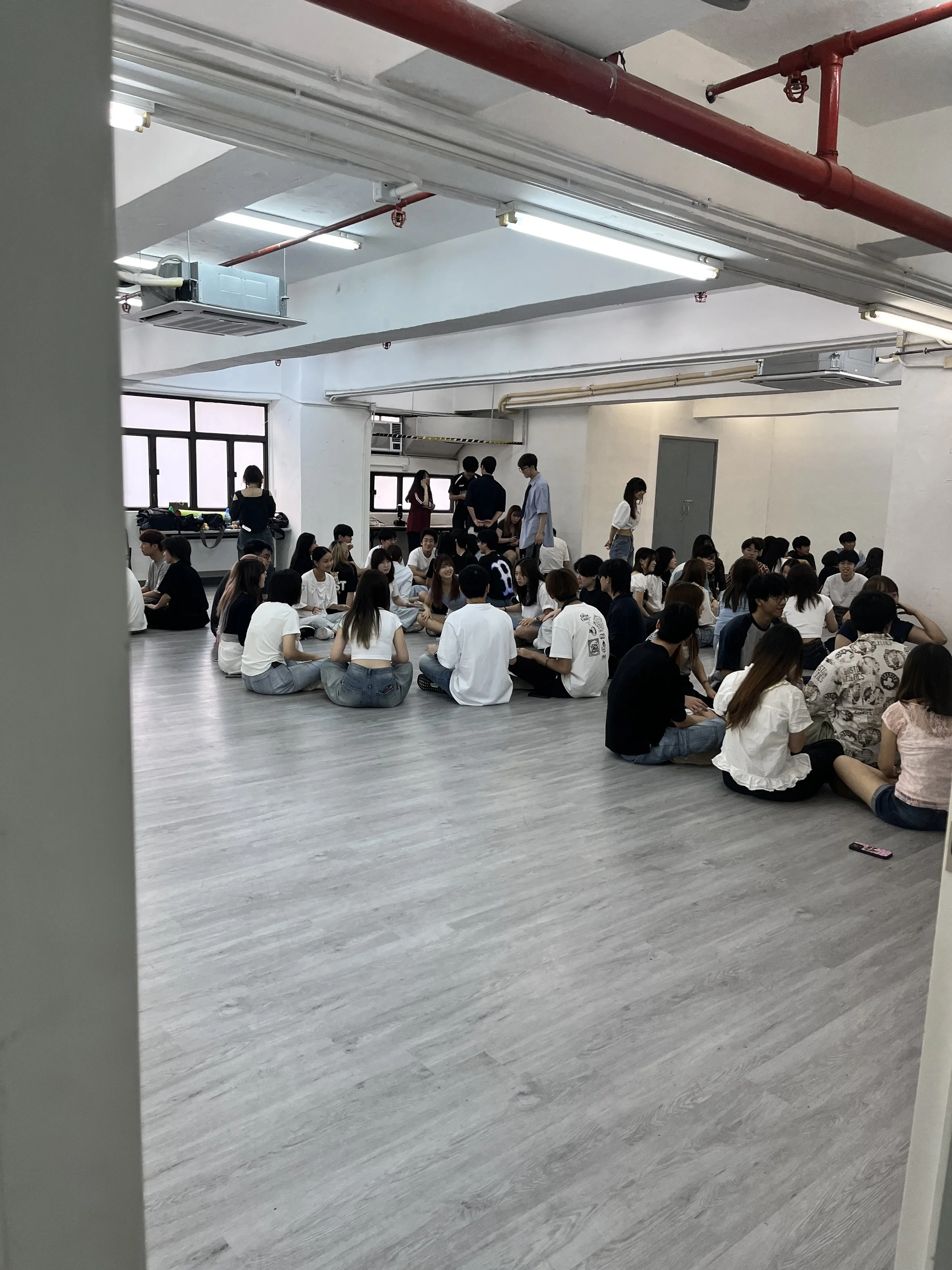An interactive corporate training section configured with seminar tables, white folding chairs, and a whiteboard for team building workshops at The Hang.
