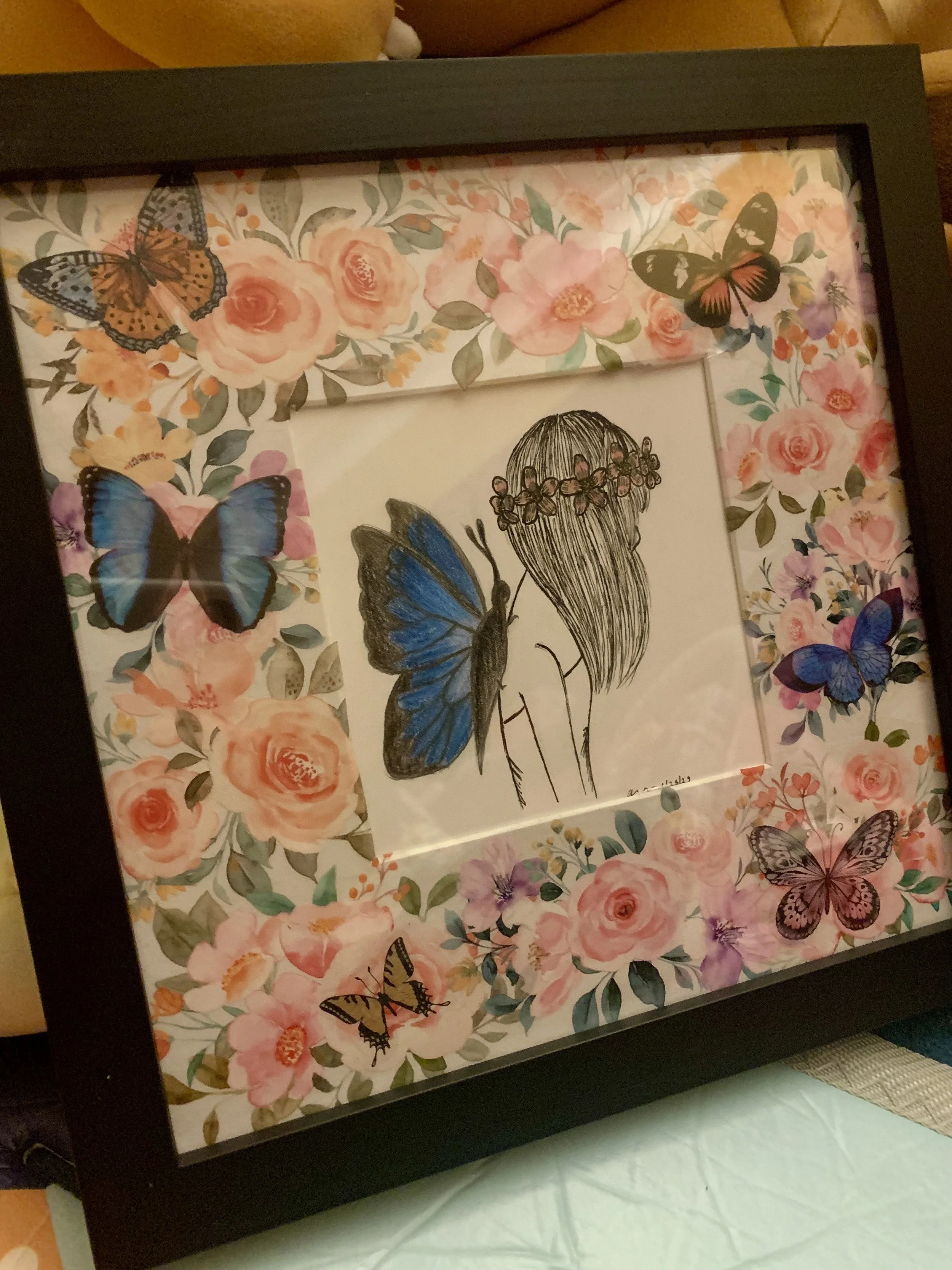 A fairy (person with a butterfly on their back) in the middle of a flower field. Made with ink, colored pencils and stickers.