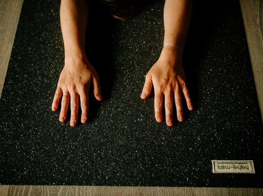 Zwei Hände auf einer Yogamatte