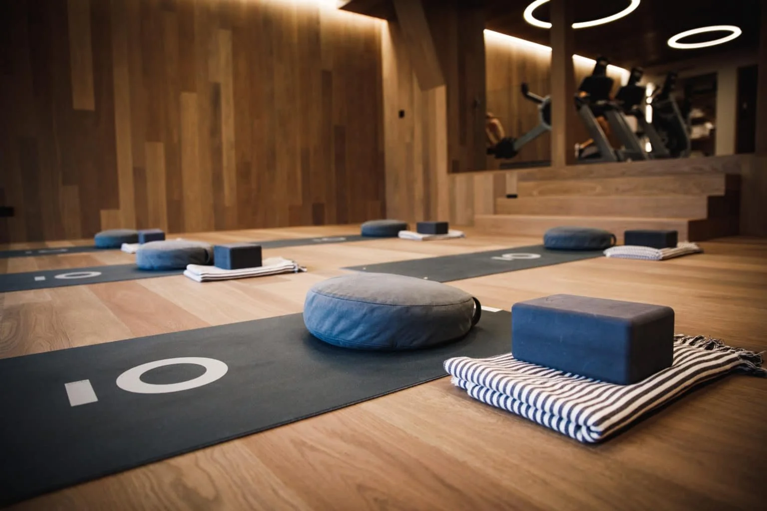 Yoga-Matten mit Kissen, Blöcken und Decken in einem ruhigen Fitnessstudio