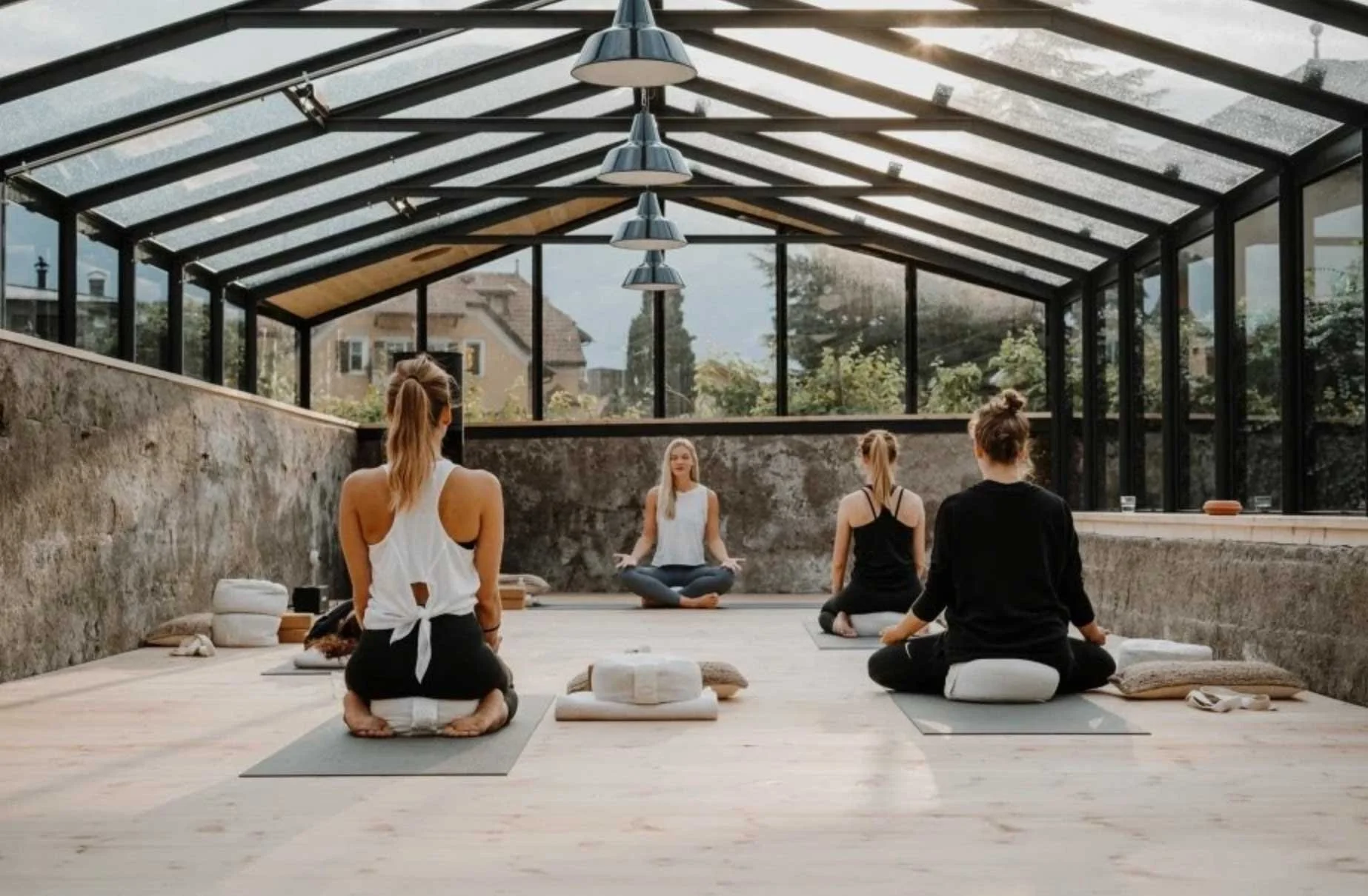Menschen, die in einem hellen Gebäude Yoga praktizieren.