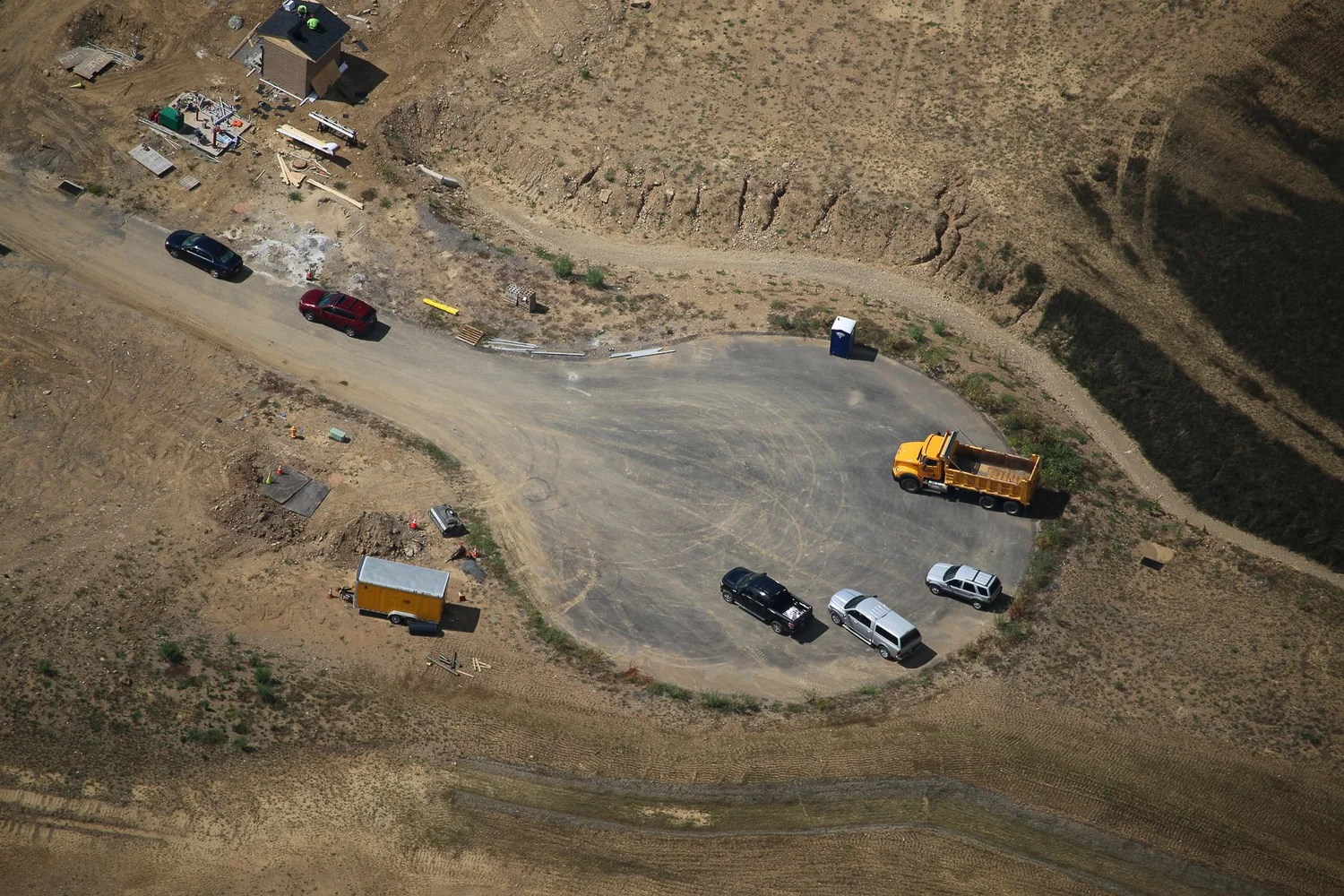 Aerial photo of a road intersection under construction with multiple construction vehicles and equipment.