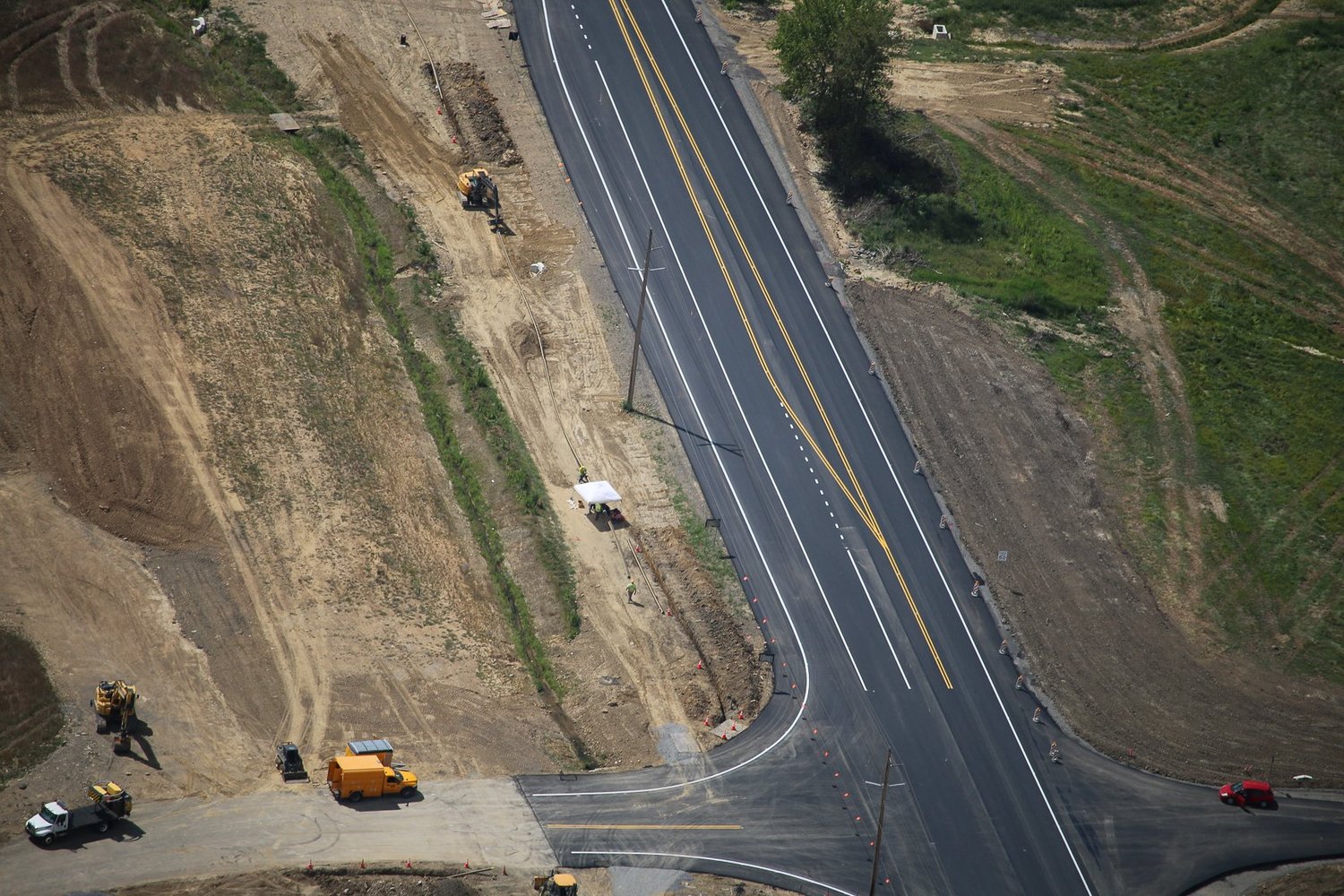 Aerial view of a construction site with dirt paths, construction vehicles, and equipment.