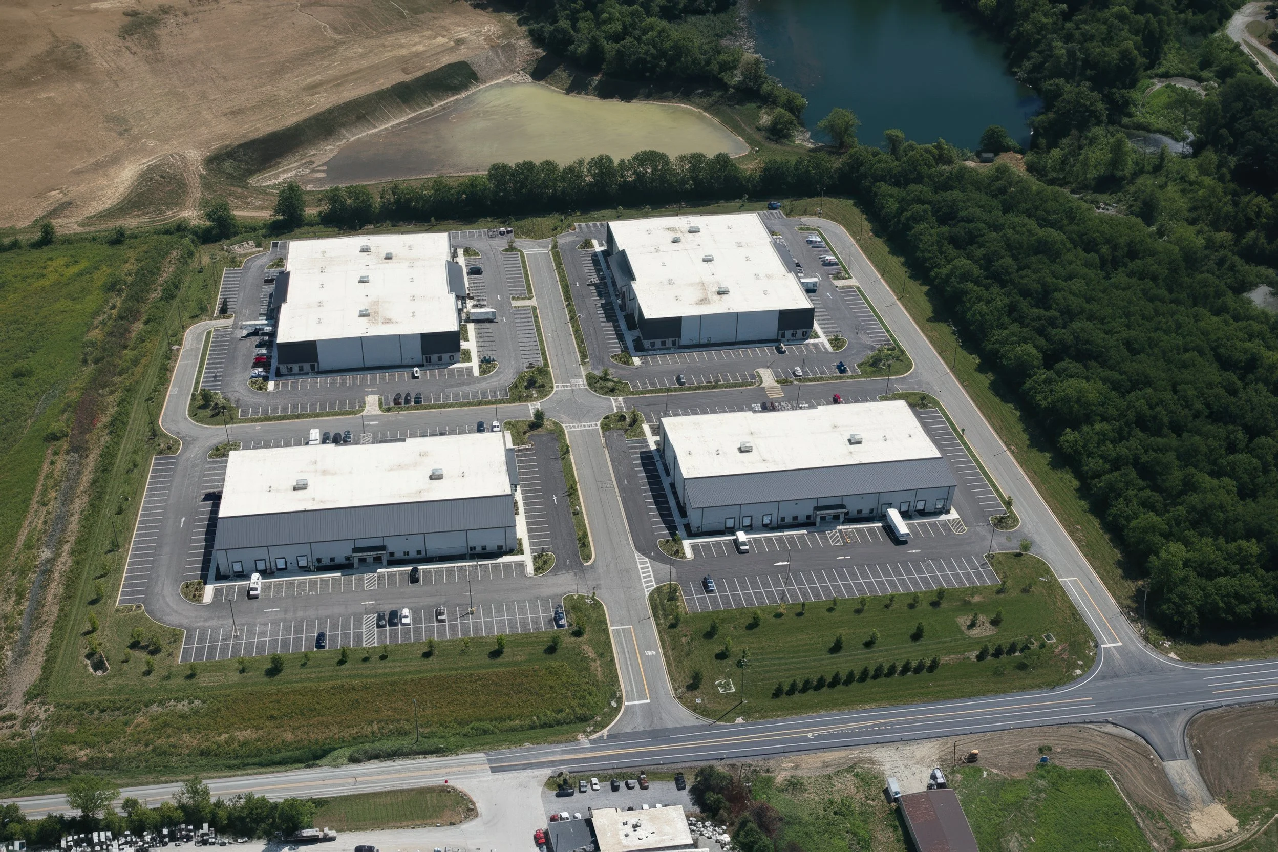 Photo-real concept for Stonecrest Business Park in New Beaver, PA: multiple light-industrial/flex buildings, internal loop road, truck courts, striped parking, and landscaped stormwater ponds with direct PA-18 access—showing build-to-suit potential.