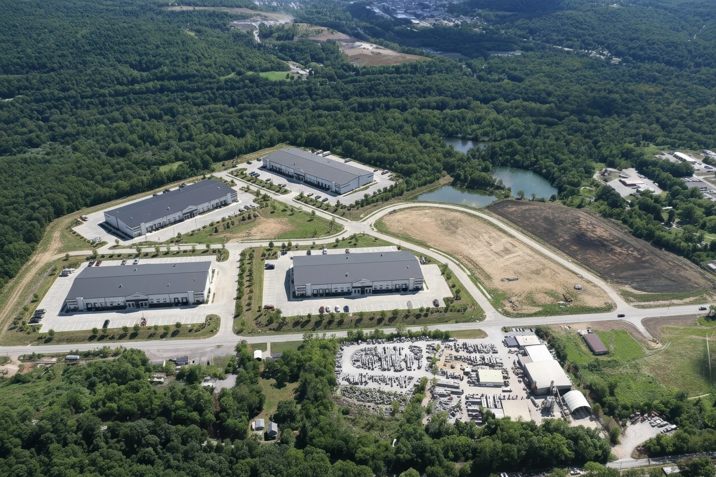 Photo-real concept for Stonecrest Business Park in New Beaver, PA: multiple light-industrial/flex buildings, internal loop road, truck courts, striped parking, and landscaped stormwater ponds with direct PA-18 access—showing build-to-suit potential.