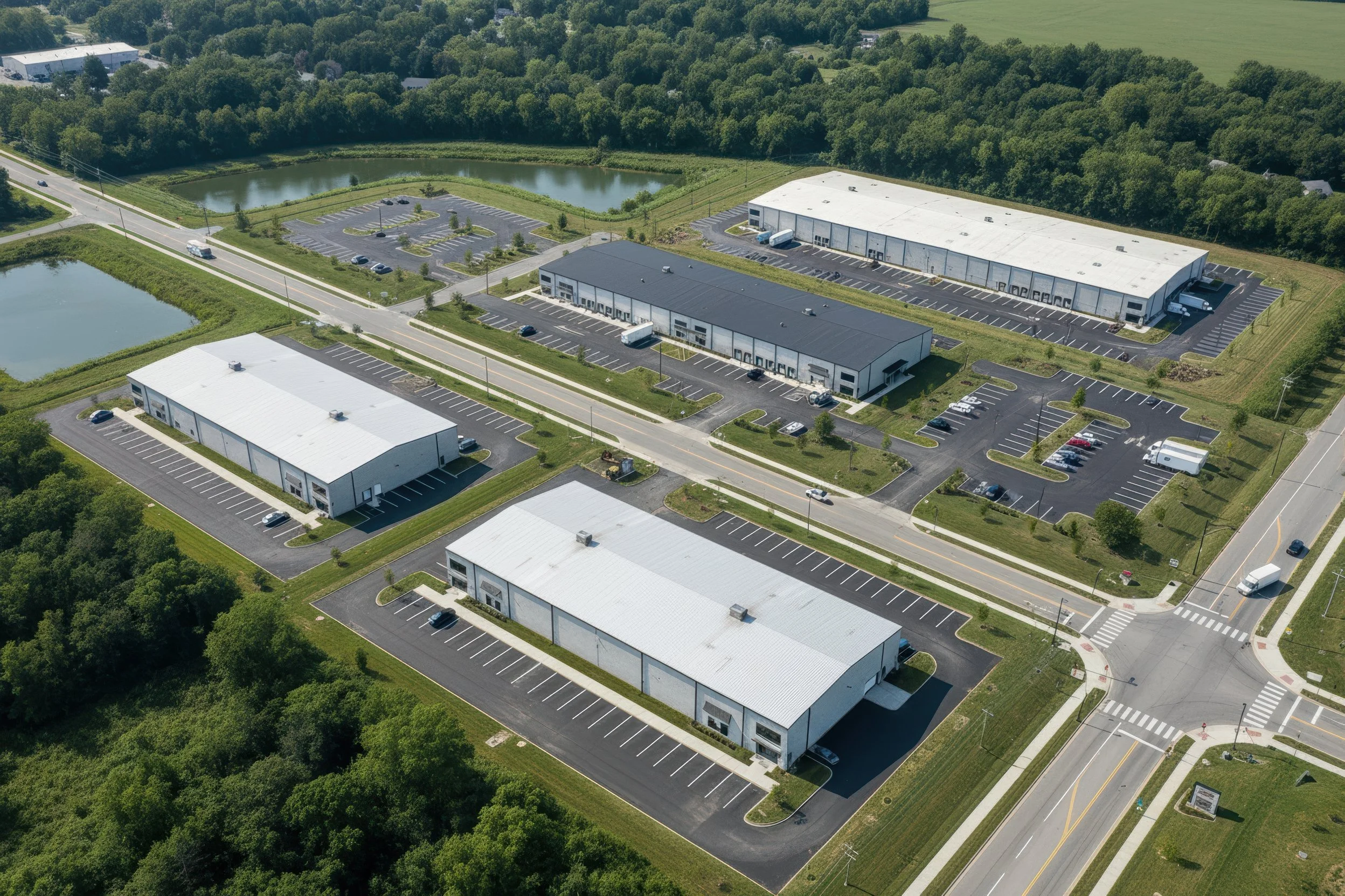 Photo-real concept for Stonecrest Business Park in New Beaver, PA: multiple light-industrial/flex buildings, internal loop road, truck courts, striped parking, and landscaped stormwater ponds with direct PA-18 access—showing build-to-suit potential.