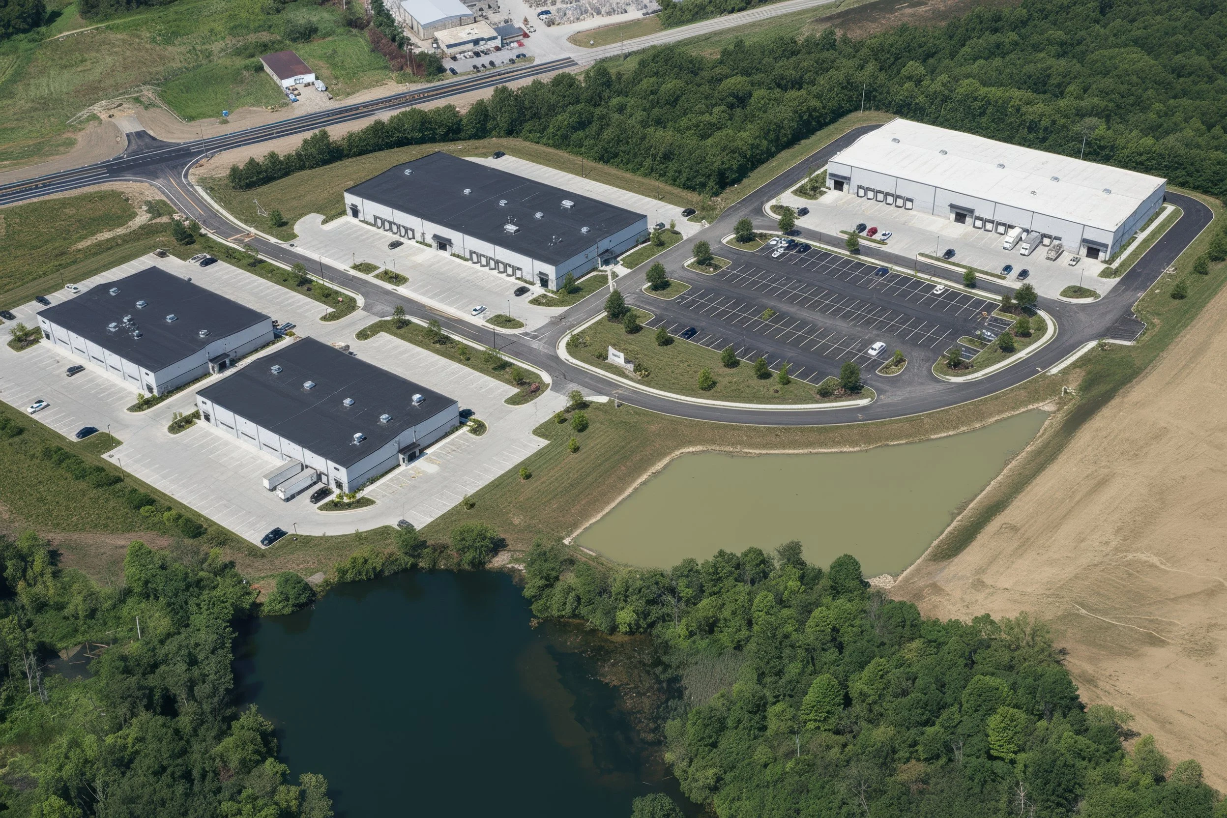 Photo-real concept for Stonecrest Business Park in New Beaver, PA: multiple light-industrial/flex buildings, internal loop road, truck courts, striped parking, and landscaped stormwater ponds with direct PA-18 access—showing build-to-suit potential.