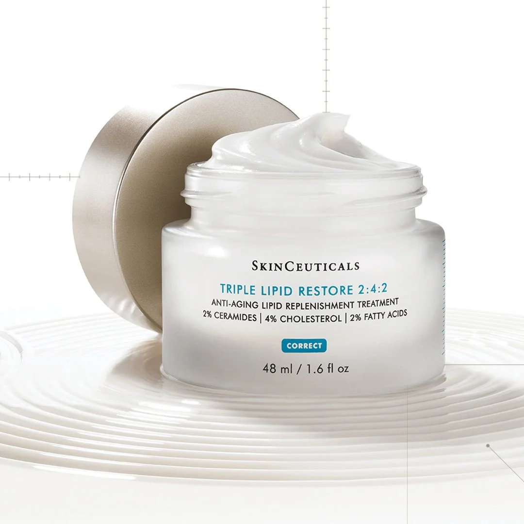 Open jar of SkinCeuticals Triple Lipid Restore moisturizer with cream inside, placed on a white surface.