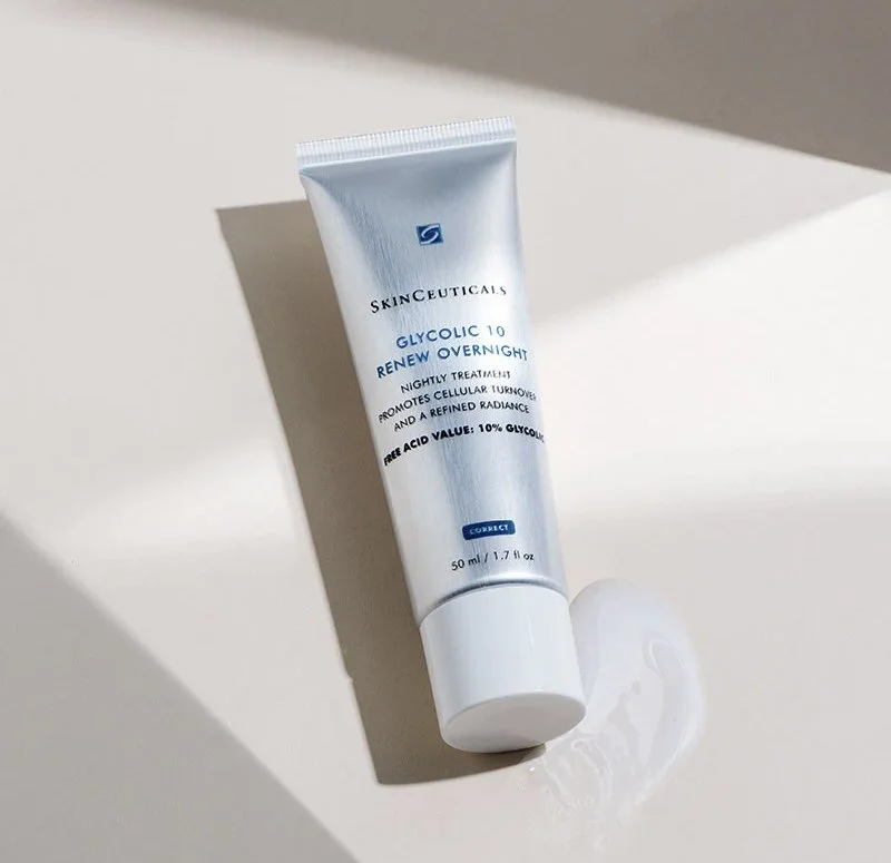 A silver tube of Skinceuticals Glycolic 10 Renew Overnight on a white surface with a small amount of cream next to it.