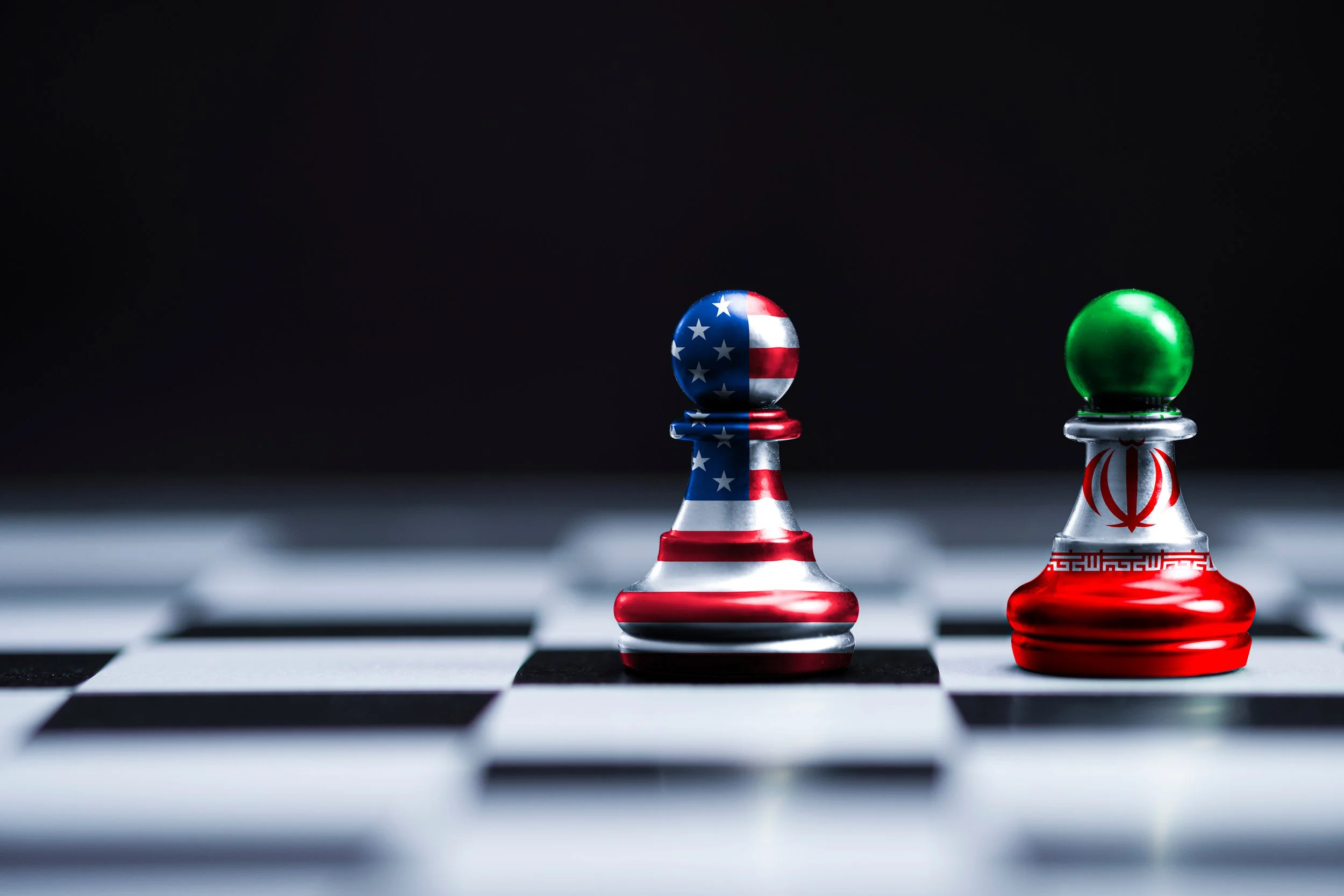 A chessboard with an American flag piece and an Iranian flag piece show the conflict between the US and Iran in the scope of Iran's disinformation war.