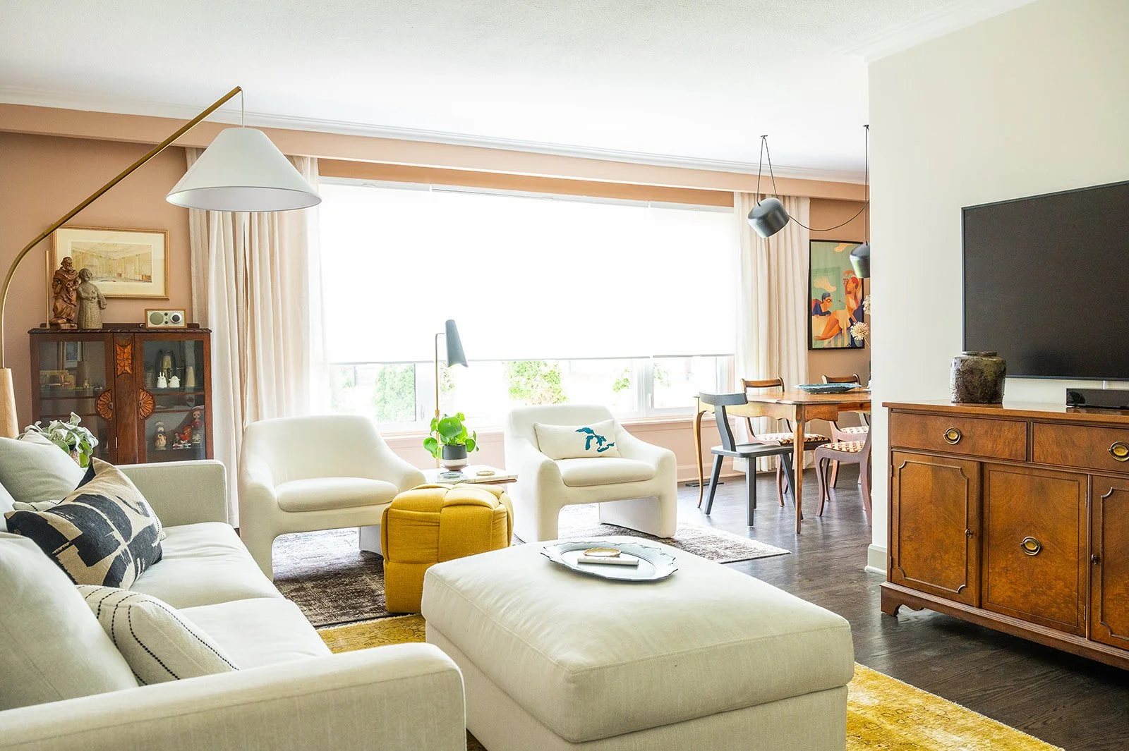 Interior design by Melissa Peretti for a North York home. Soft peach walls, with off white living room furniture and dark hardwood floors.