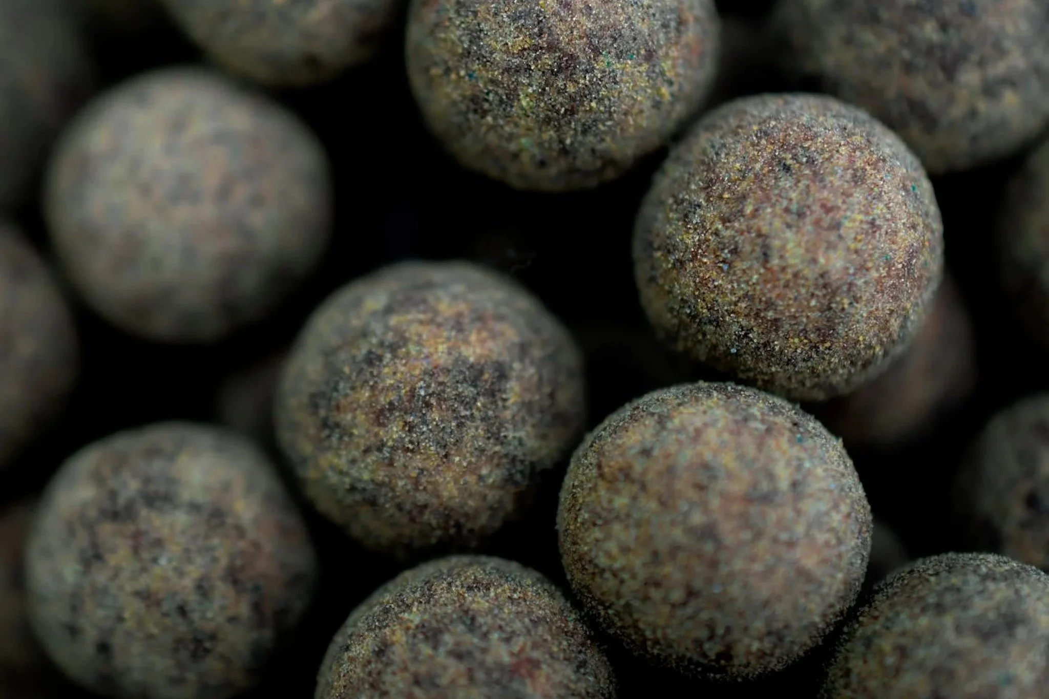 Close-up of black peppercorns showing their textured surface.