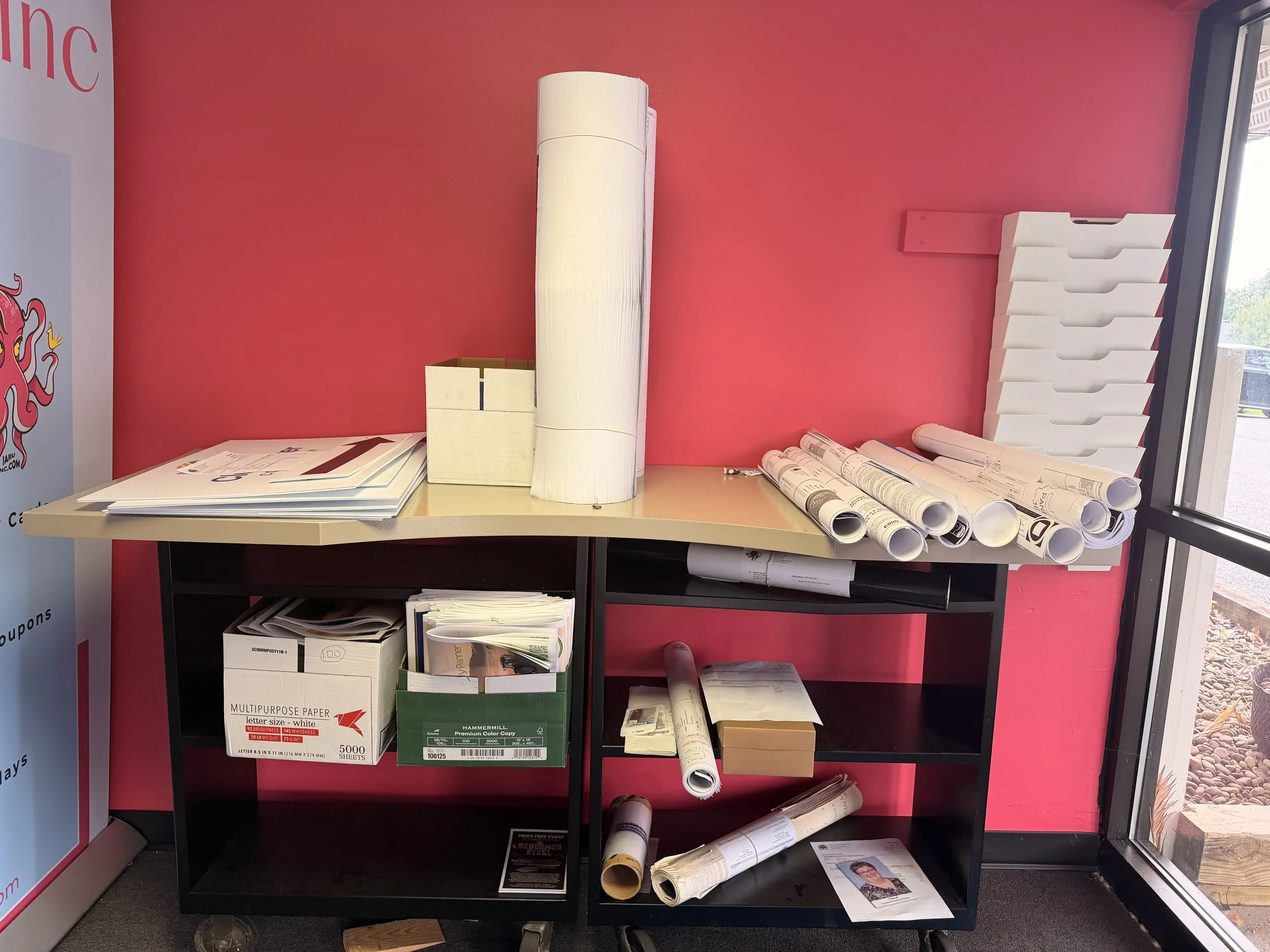 Behind the scenes at Jaru Print and Custom Apparel in State College, PA: rolls of paper, banner and sign printing supplies, and finished print orders