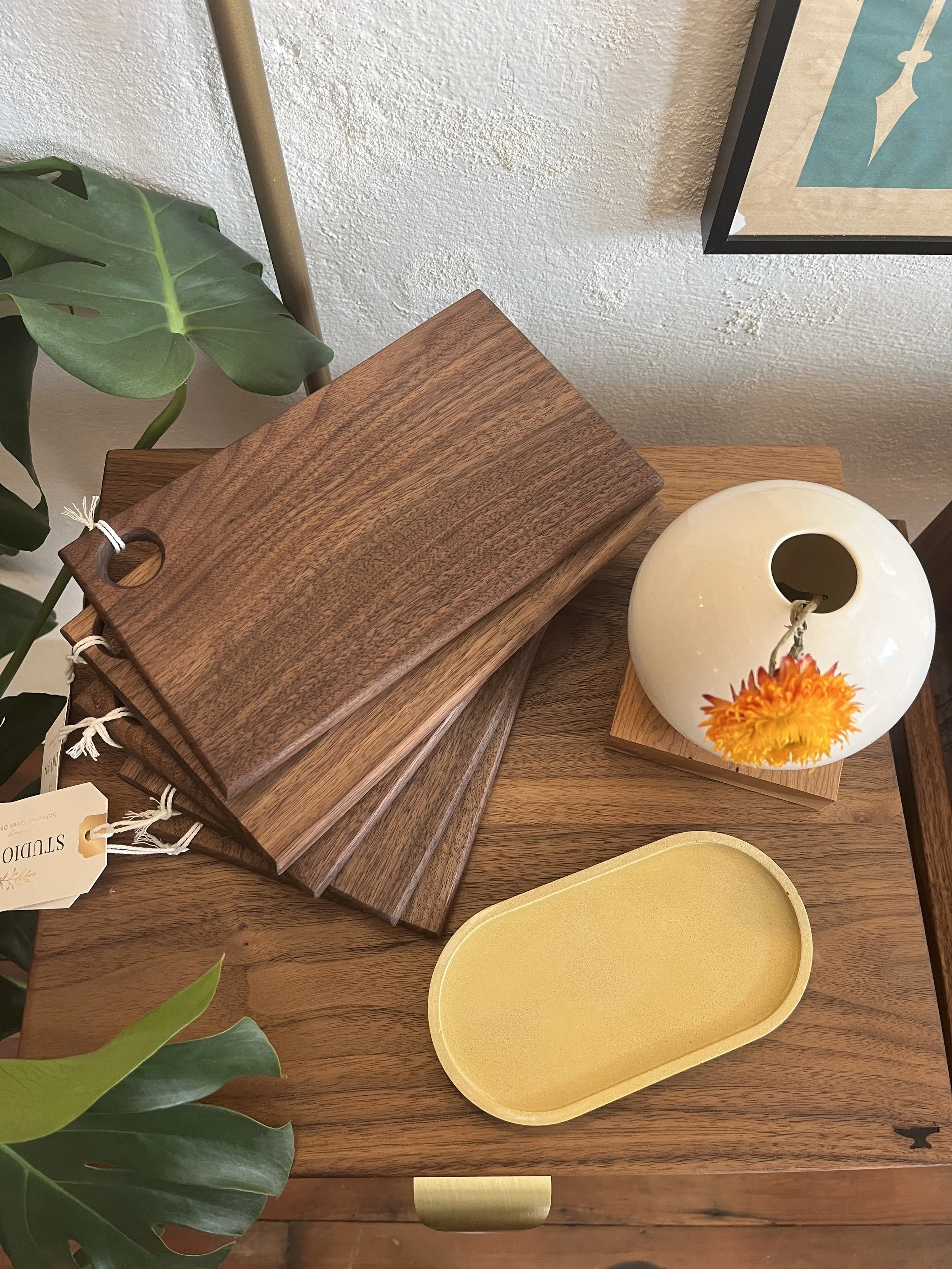 A fanned out stack of hand made wooden serving trays designed by Schooner Creek Designs