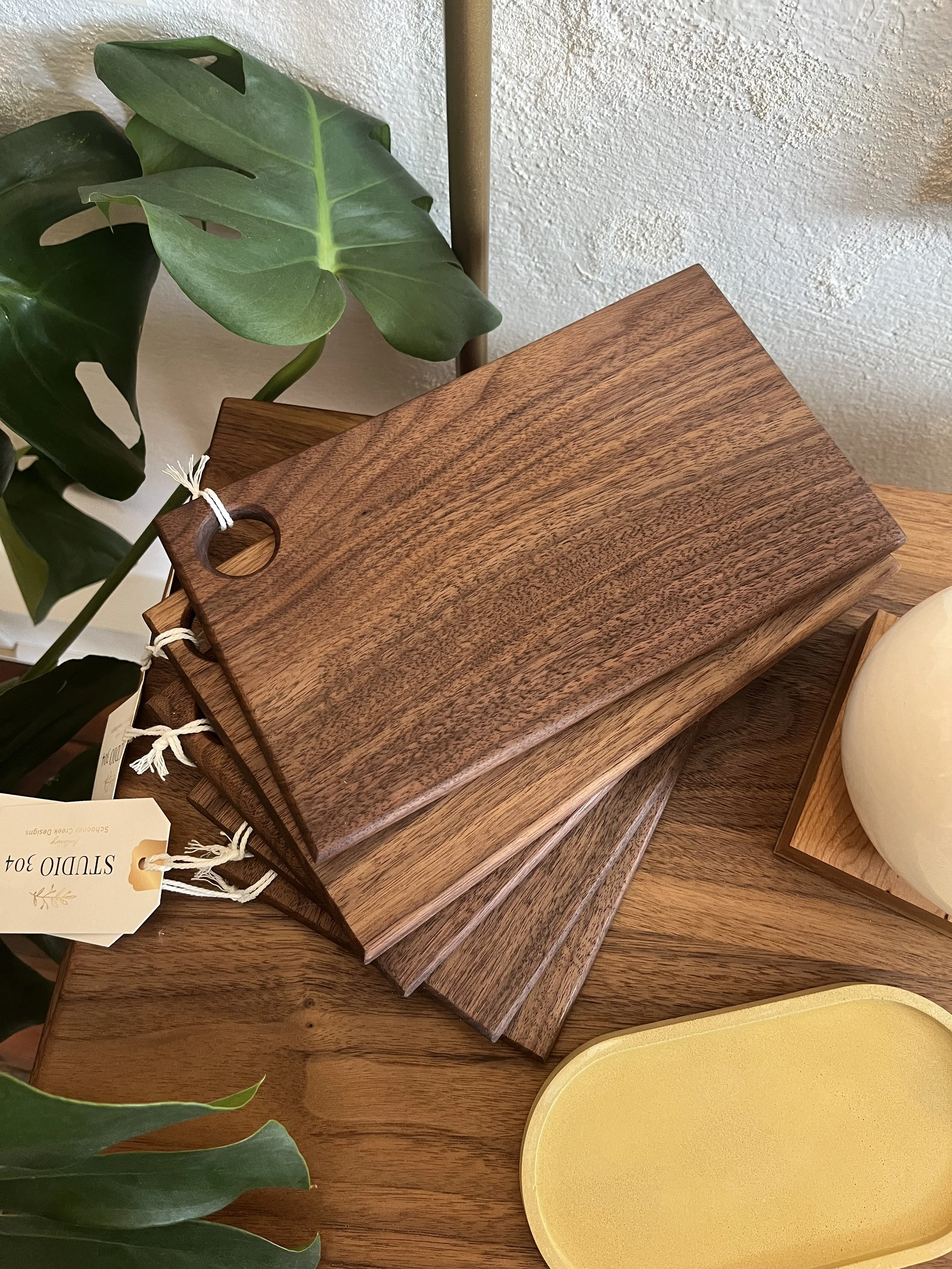 A fanned out stack of hand made wooden serving trays designed by Schooner Creek Designs