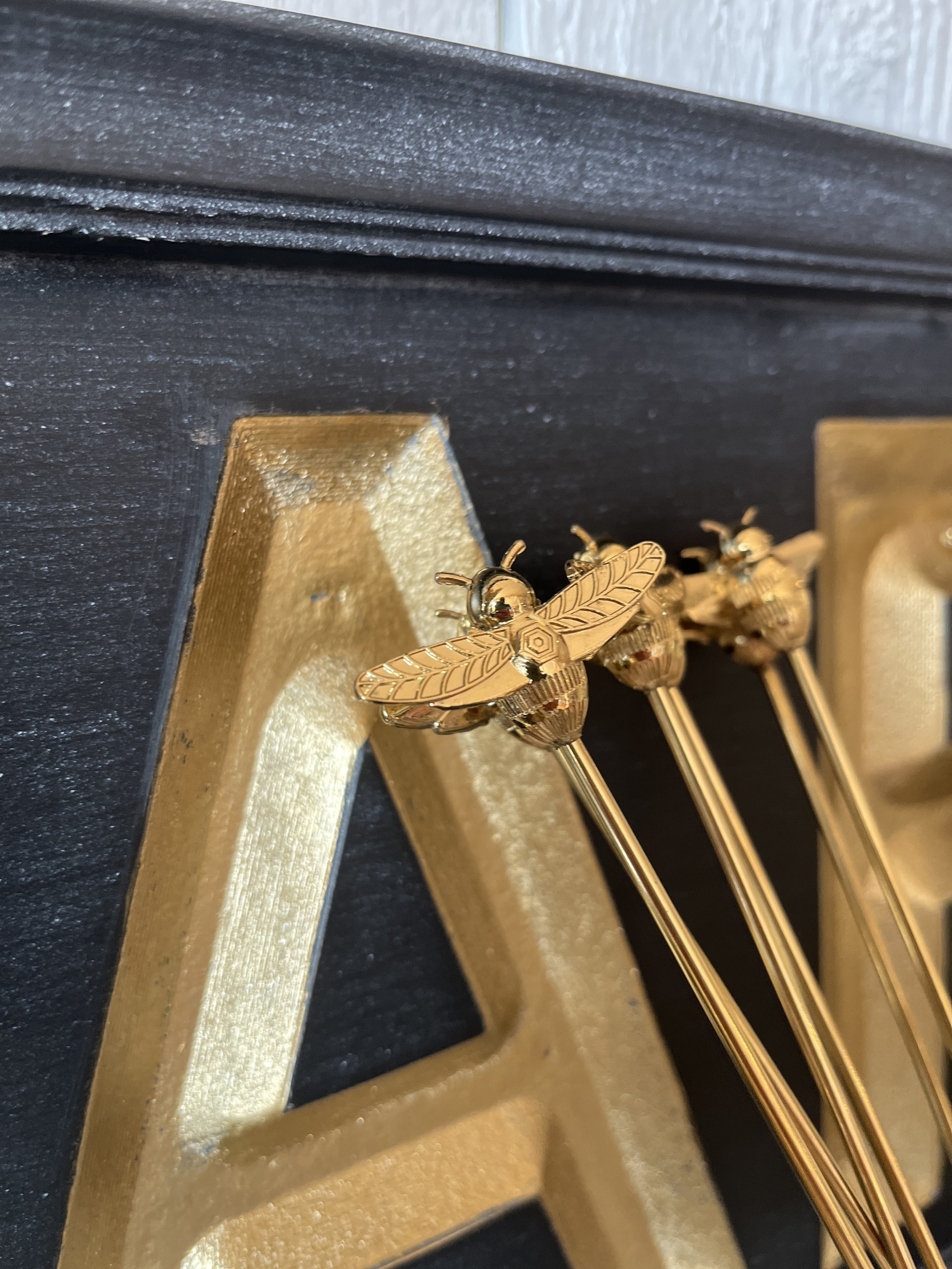 Brass Bee Stir Sticks displayed in a glass at Studio 304