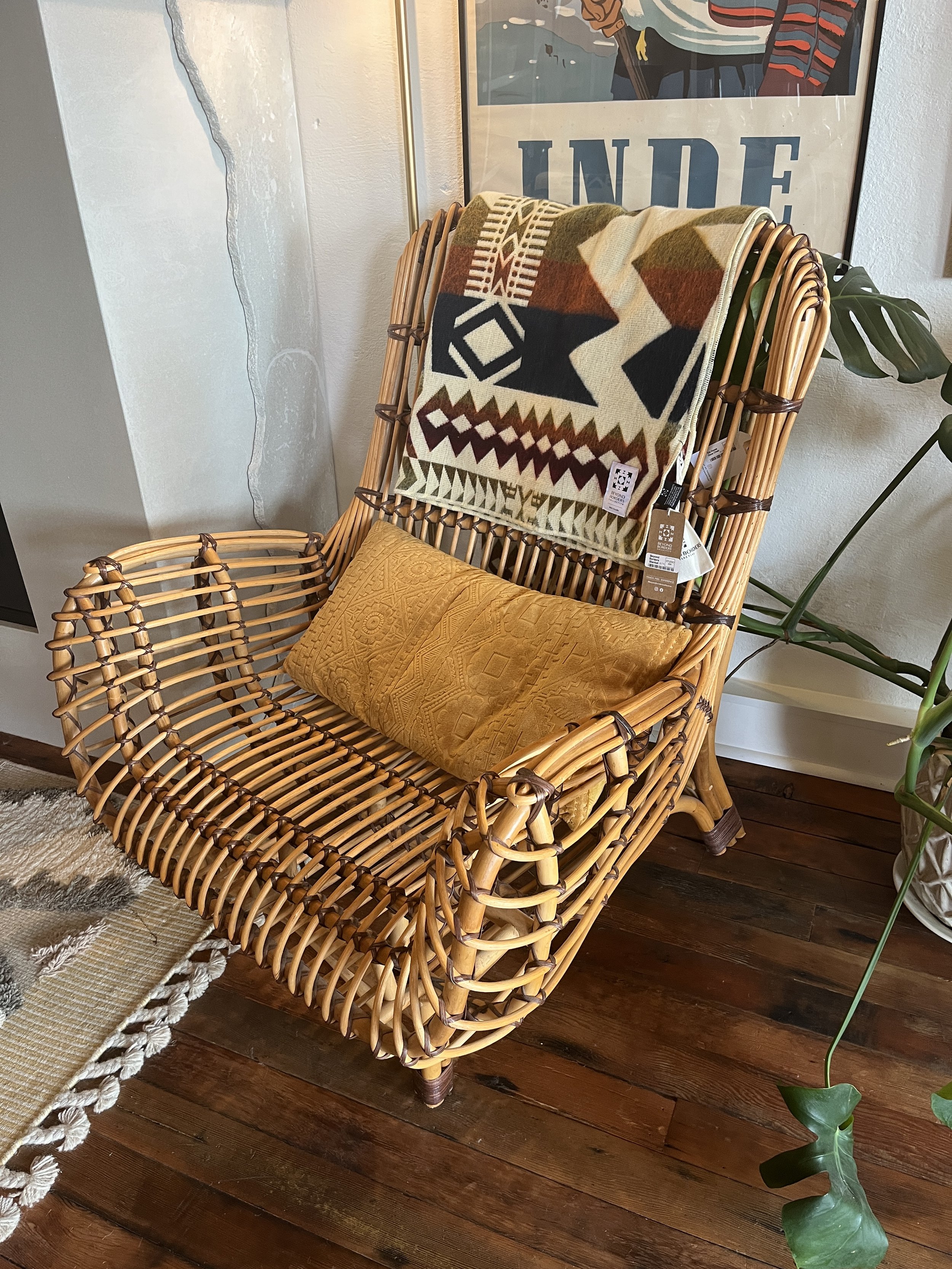 Wicker Armchair with vintage posters in the background