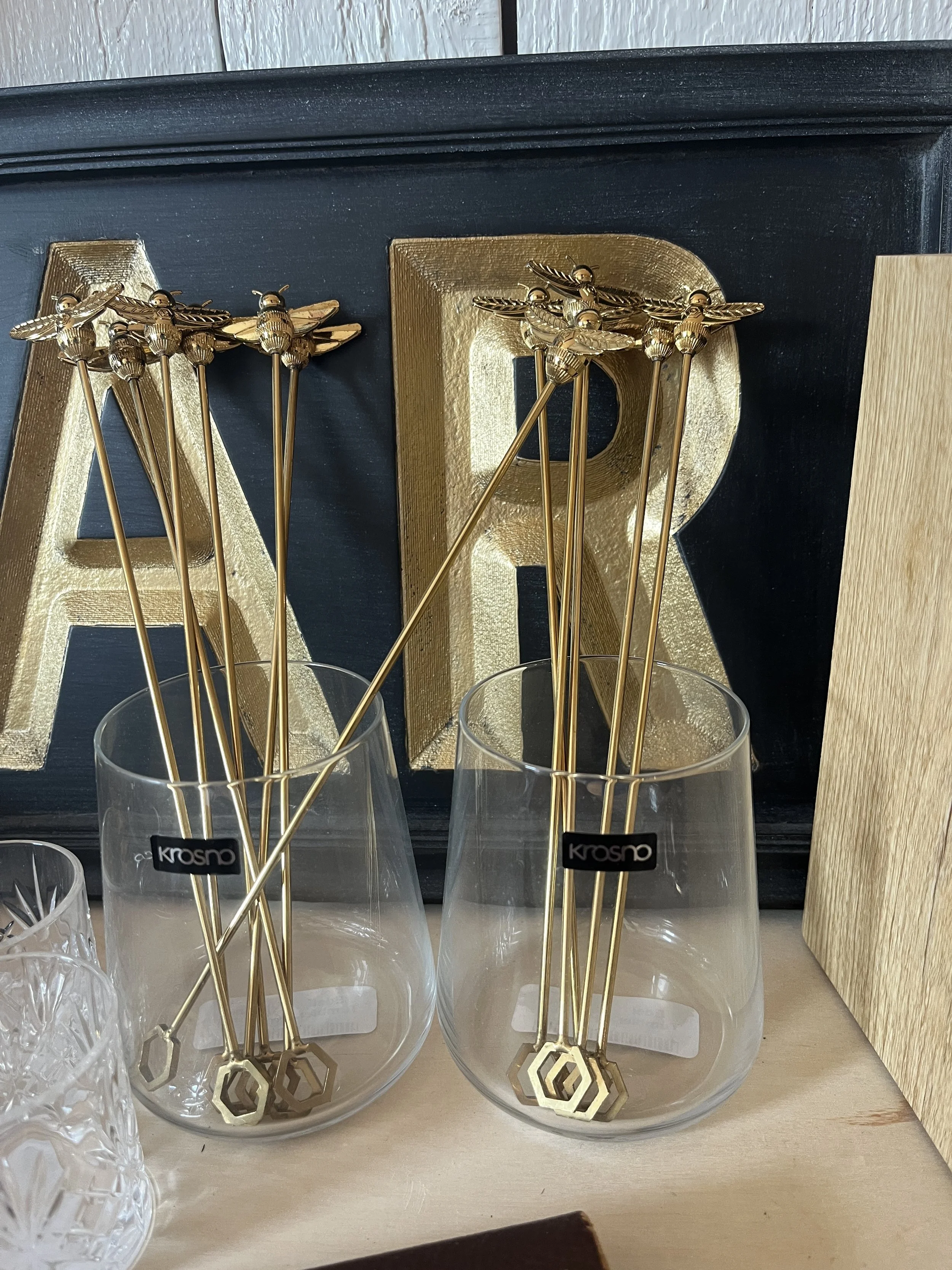 Brass Bee Stir Sticks displayed in a glass at Studio 304