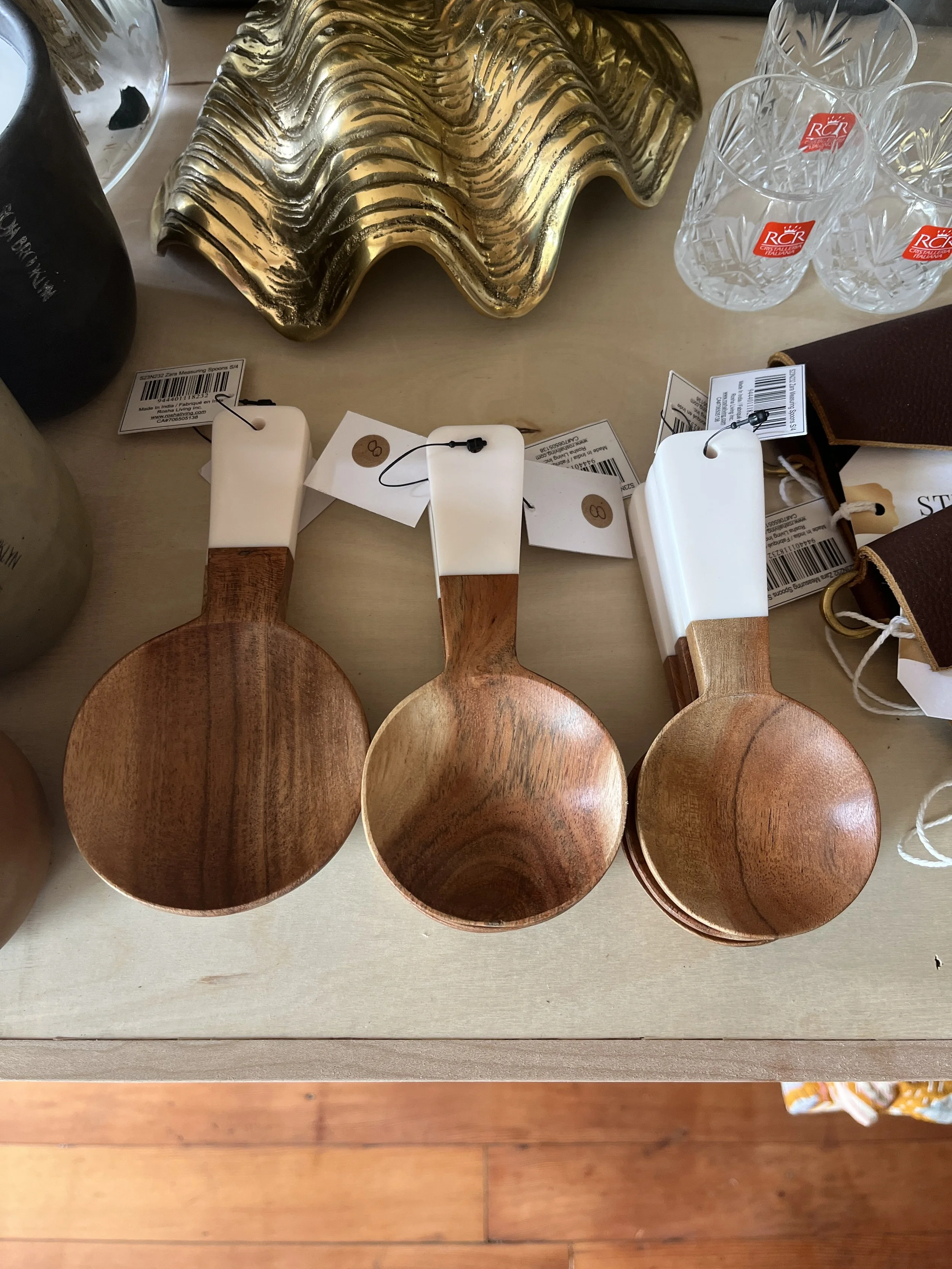 Three different size wooden measuring spoons with white handles displayed at Studio 304