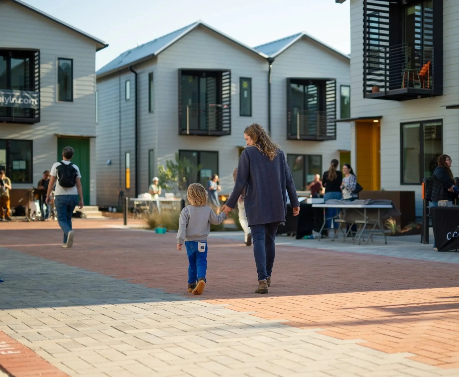 Mom and son walking hand-in-hand down Lively Lane at the Annual Lively Lane Block Party