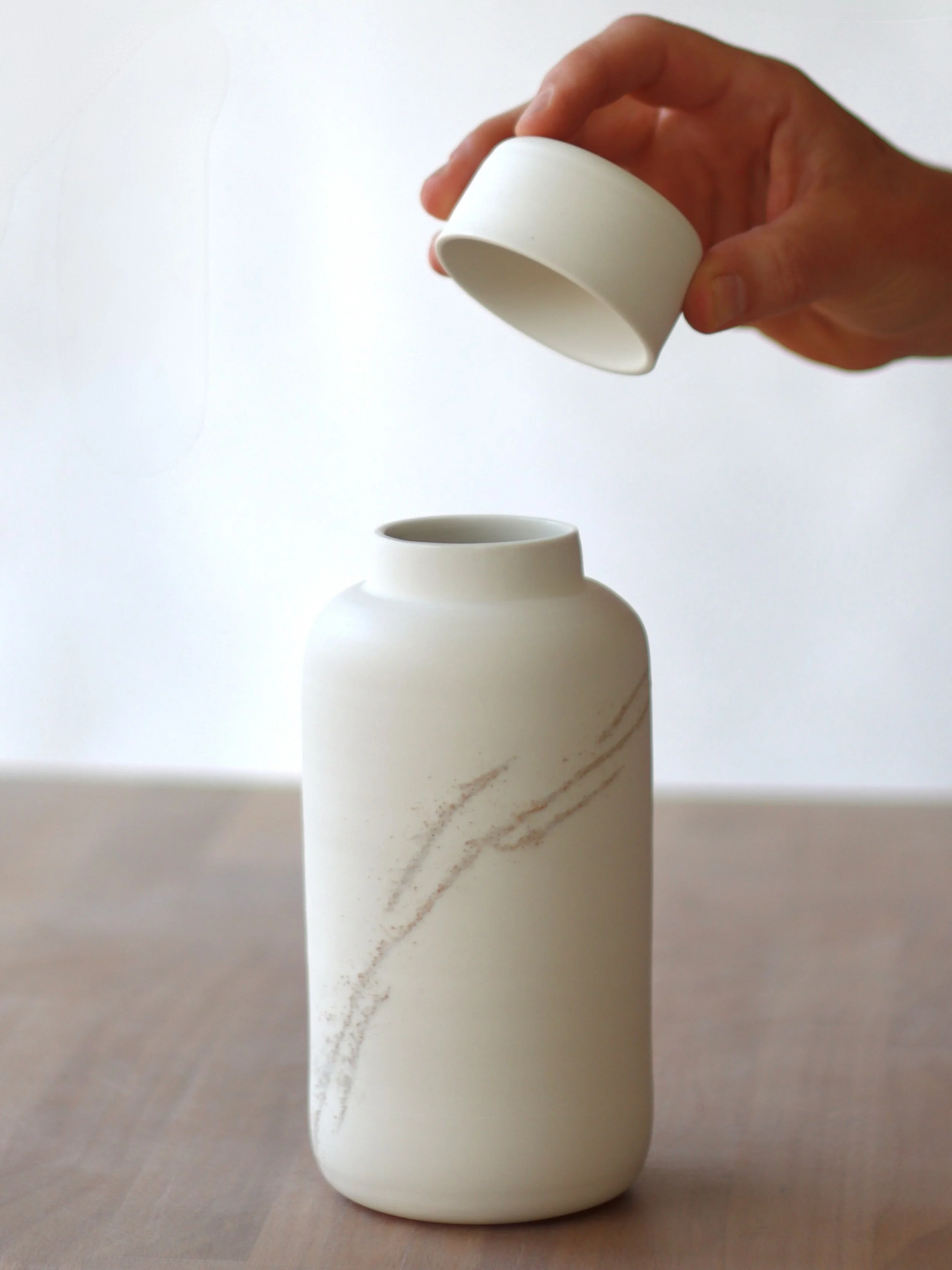 This jar is the result of another one of my recent porcelain experiments. This time I randomly inlaid pre-fired fragments from another clay body into the thrown and trimmed form. I tested a variety of grog sizes to see how they would behave in the fi