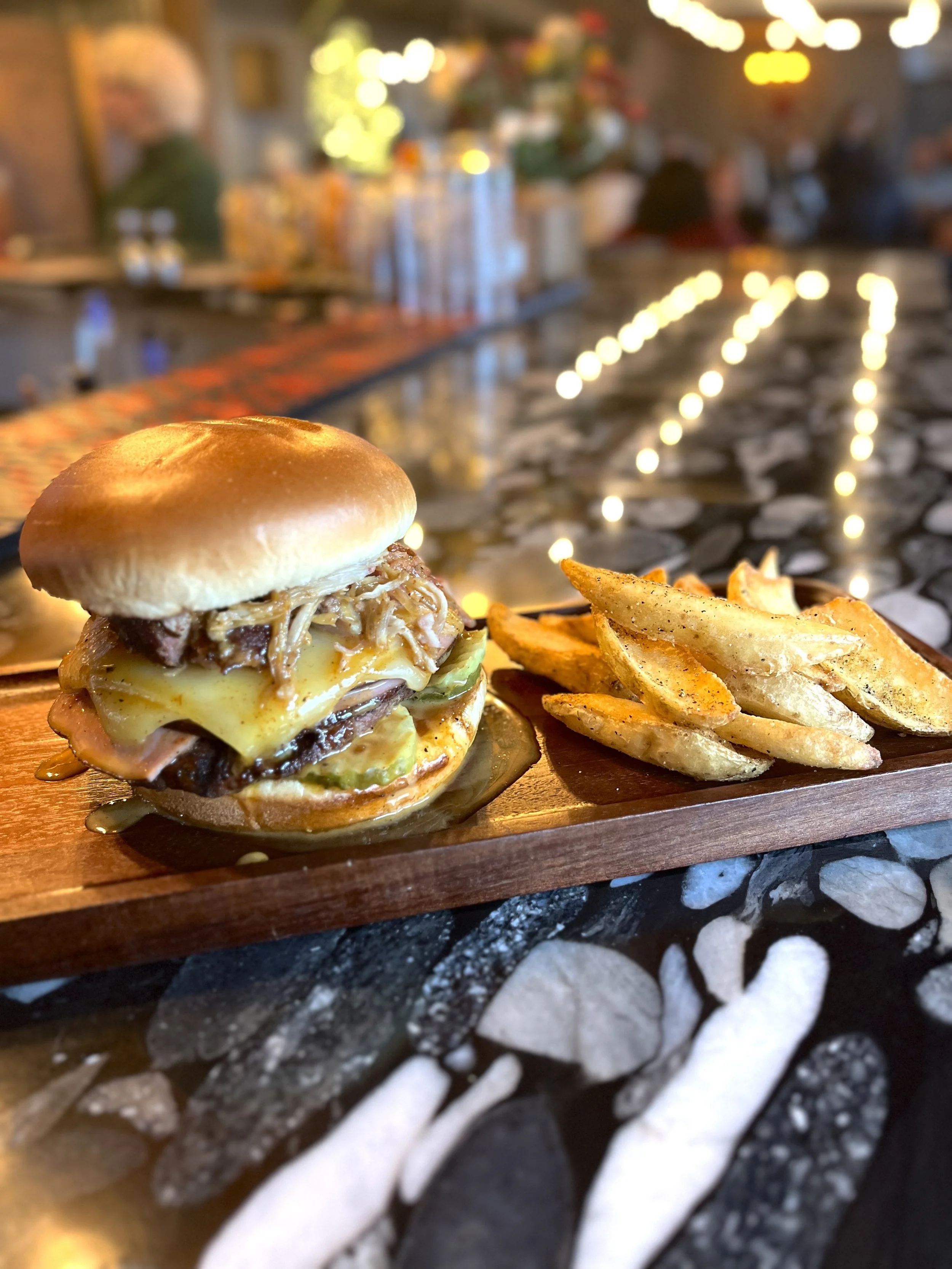 Juicy burger topped with pulled pork, BBQ sauce and cheese with a side of dipper fries.