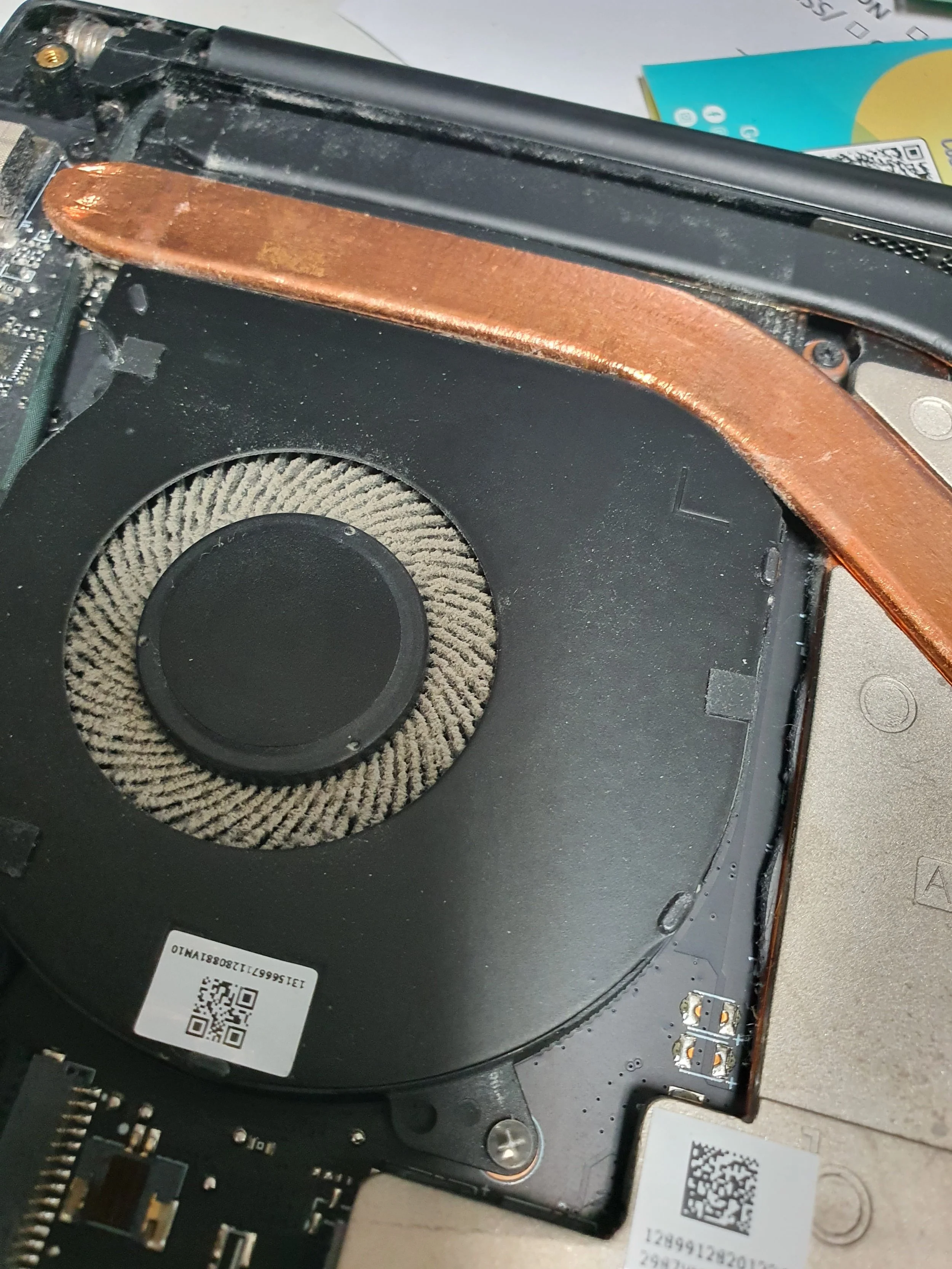 Close-up of a laptop's internal cooling fan and heat sink, with visible copper heat pipe.