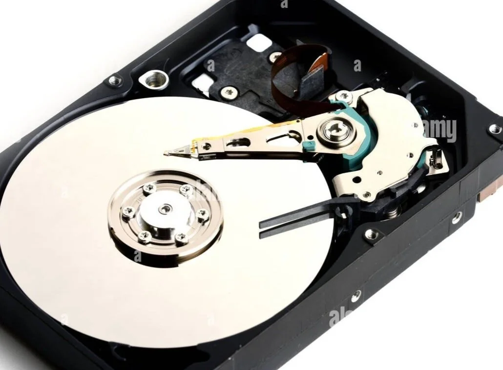 Close-up of an opened hard disk drive showing the spinning magnetic disk and read/write head.